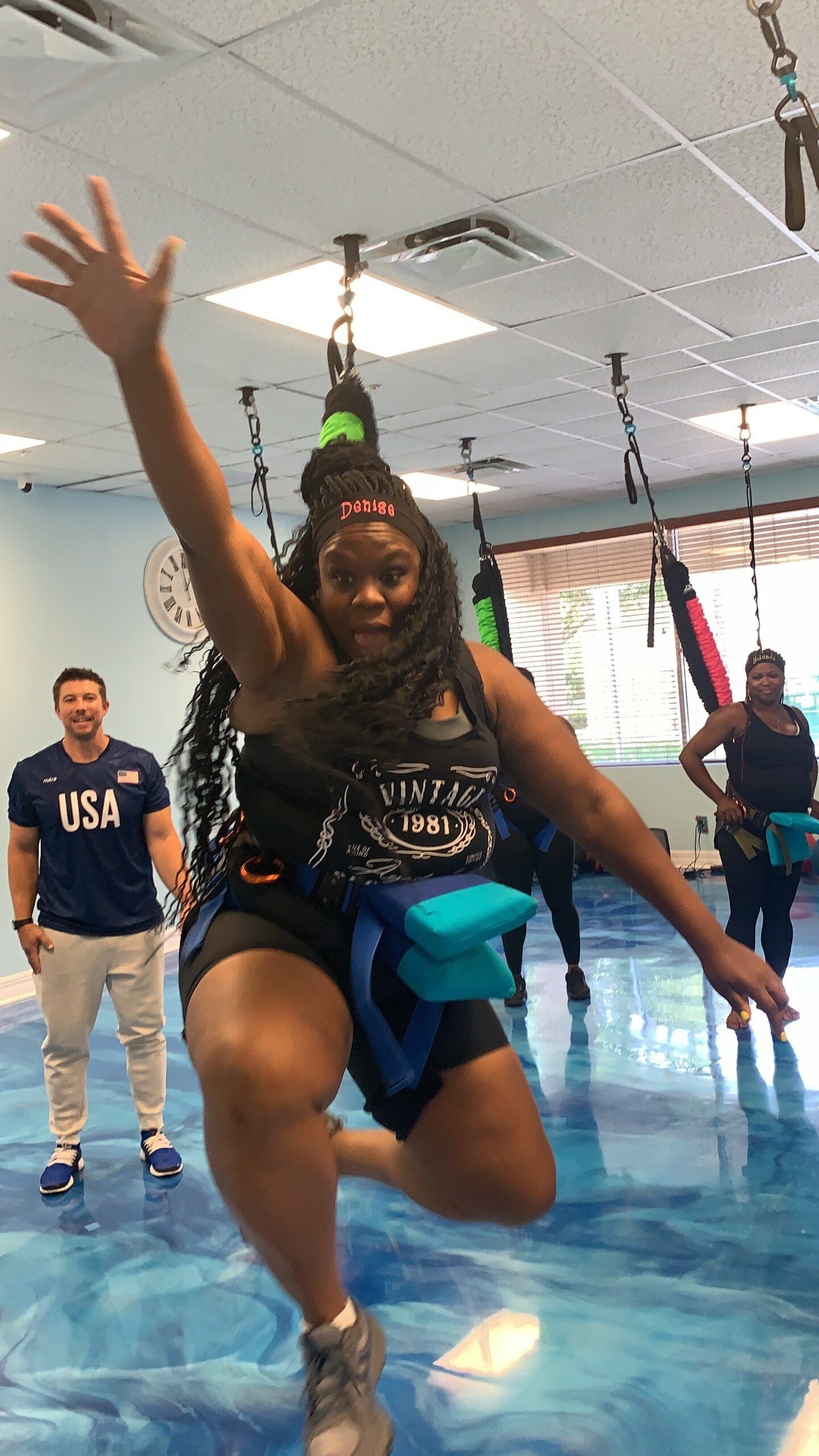 A woman is jumping in the air in a gym.