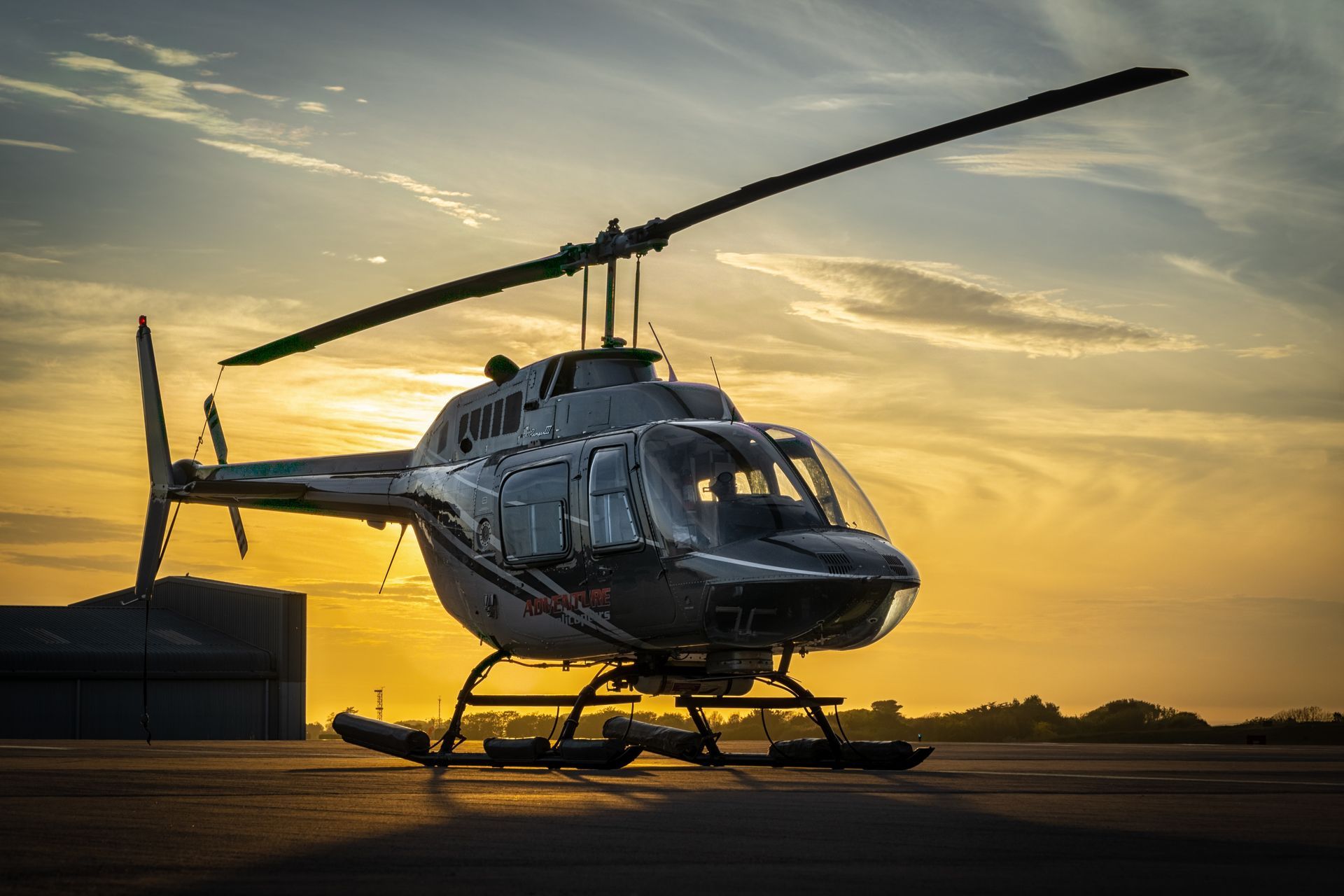 Helicopter on a runway at sunset with golden sky and long shadows Helicopter on a runway at sunset with golden sky and long shadows