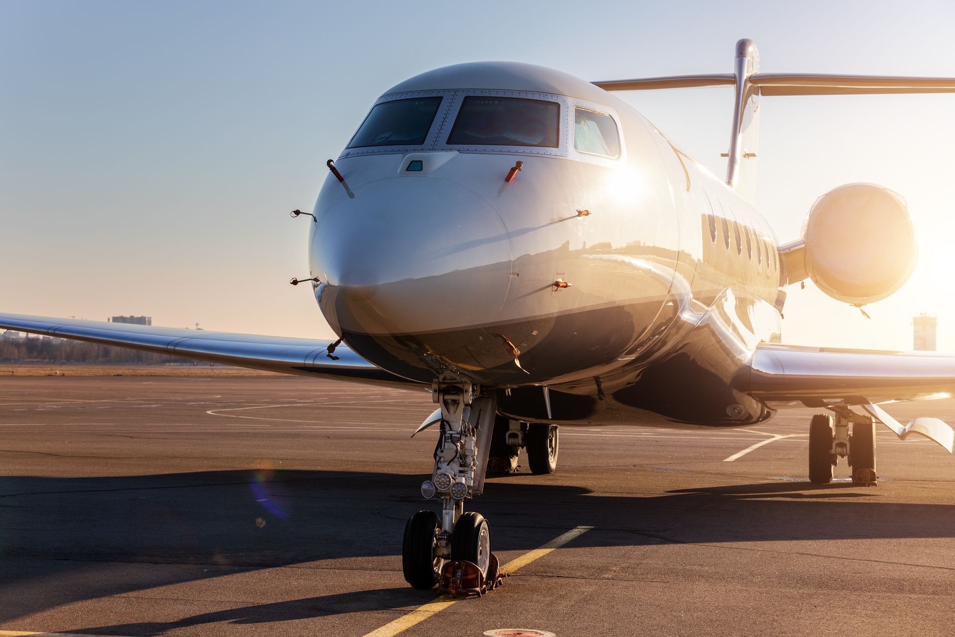 A sleek private jet parked on a sunny tarmac, illuminated by the sun. A sleek private jet parked on a sunny tarmac, illuminated by the sun.