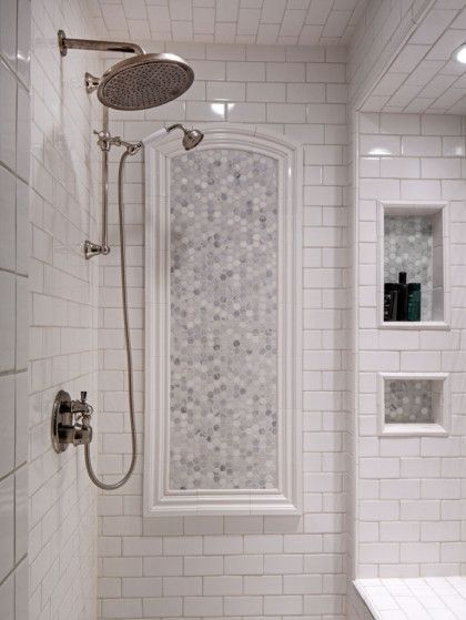 A bathroom with white tiles and a shower head - Omaha, NE - BluePrint Construction