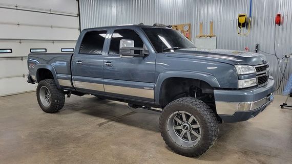 A gray pickup truck is parked in a garage.