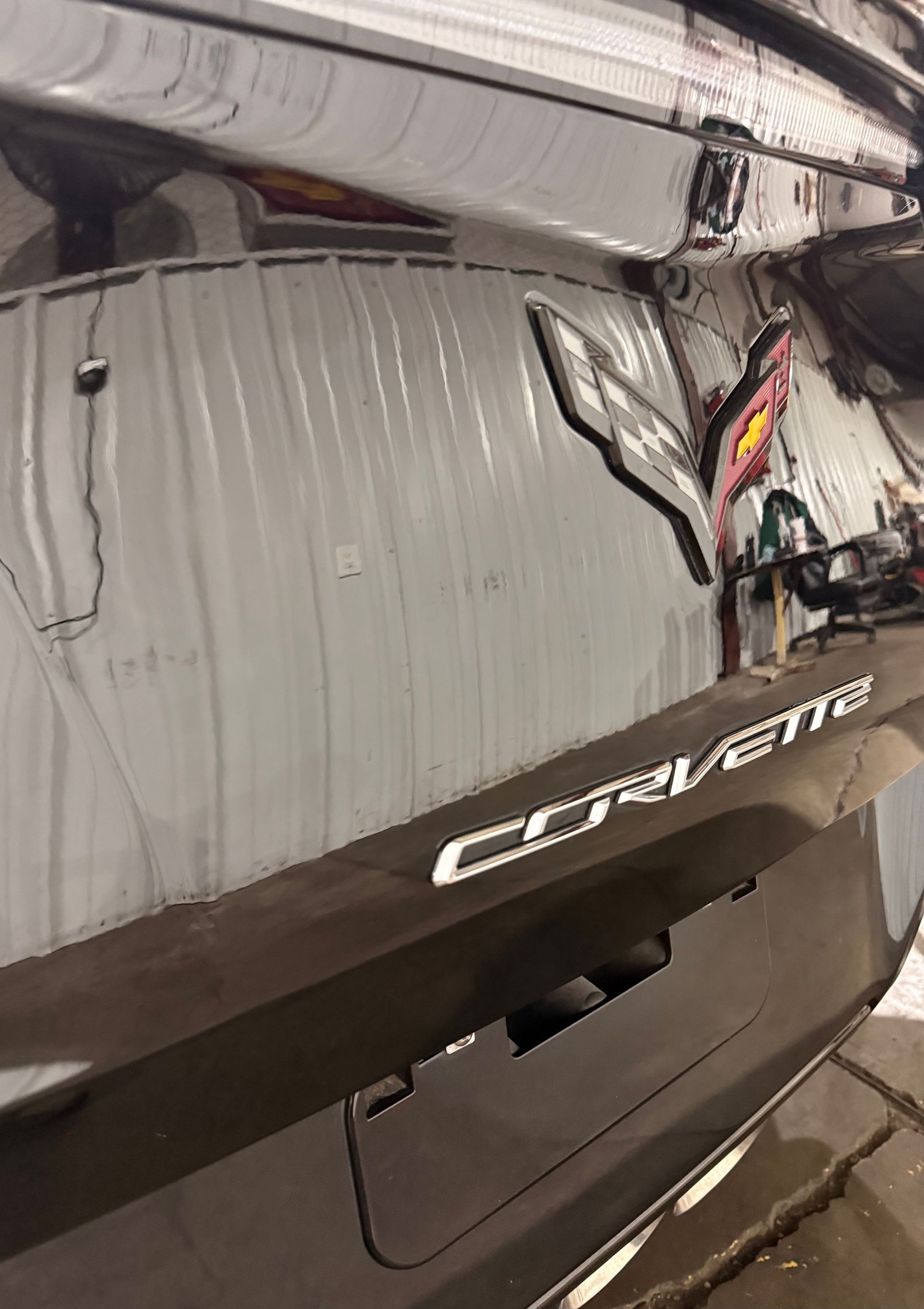 A rear view of a dark Chevrolet Corvette featuring the silver