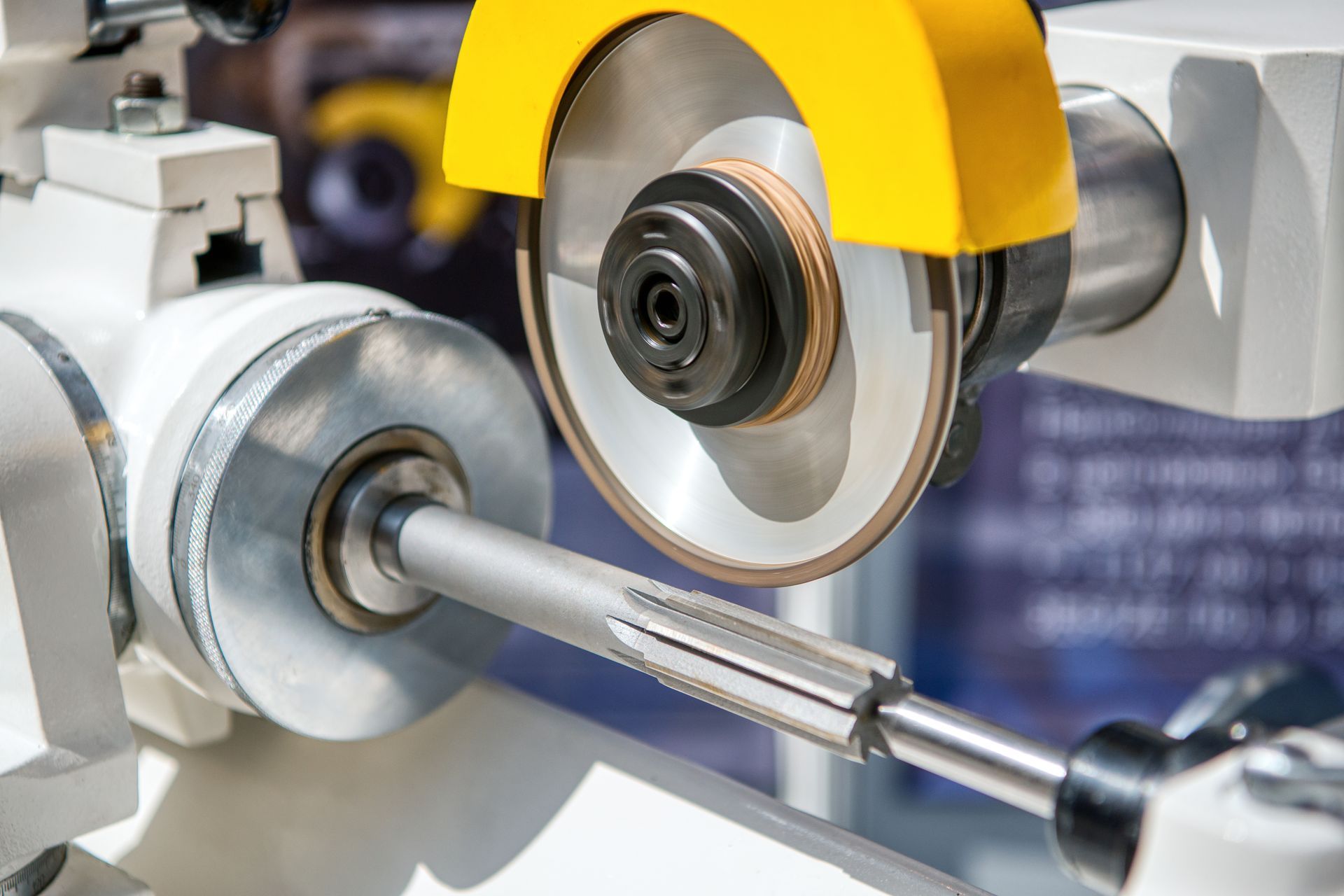 Close-up of equipment spline cutting process on steel shaft using precision grinding tool. Close-up of equipment spline cutting process on steel shaft using precision grinding tool.