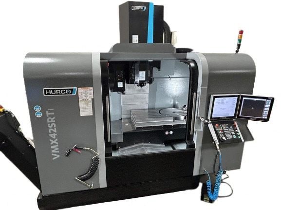 A gray Hurco VMX42SRTi CNC milling machine with two monitors and a control panel, in a workshop setting.
