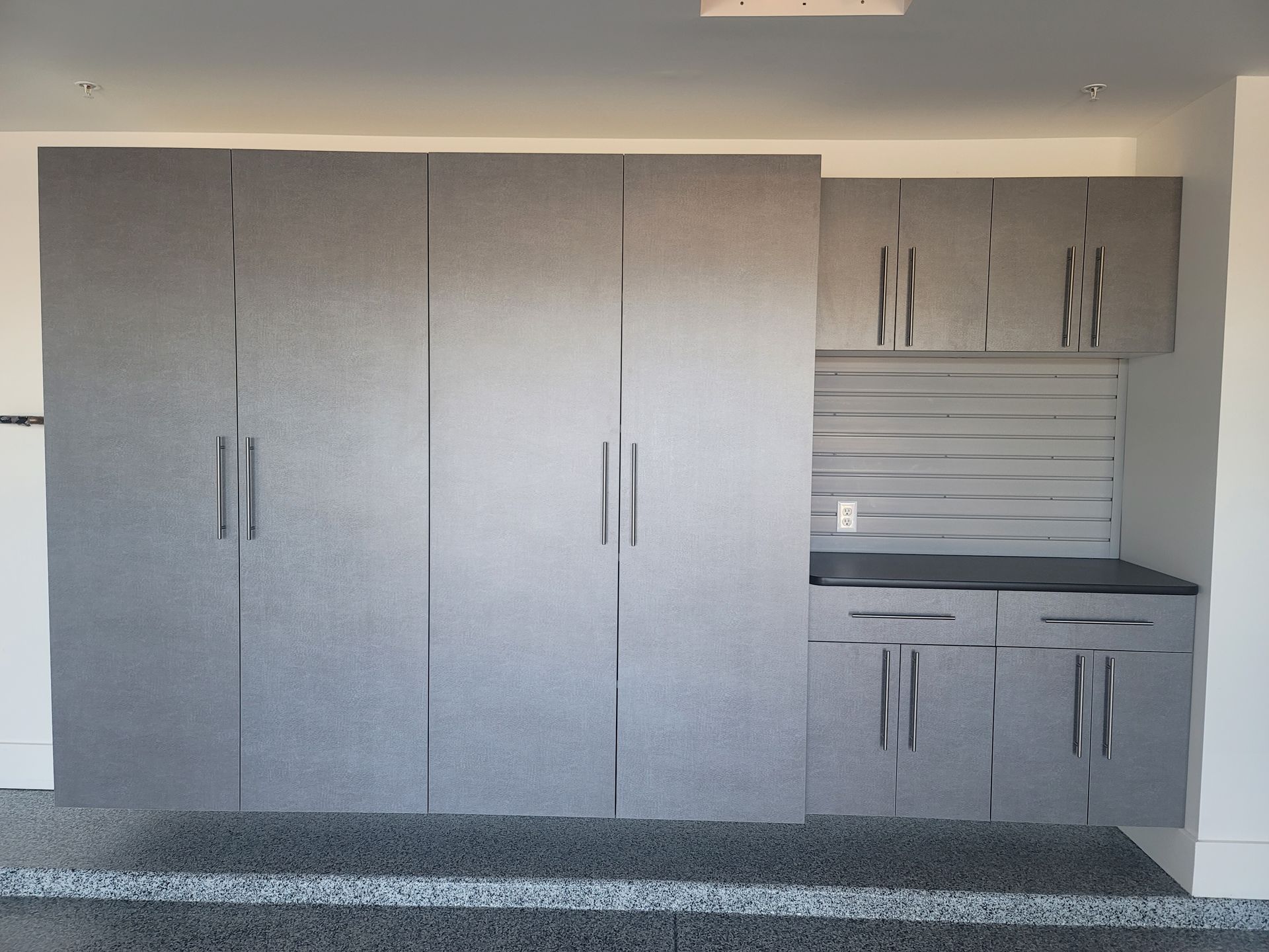 Modern gray kitchen cabinets and a countertop with upper cabinets and sink area