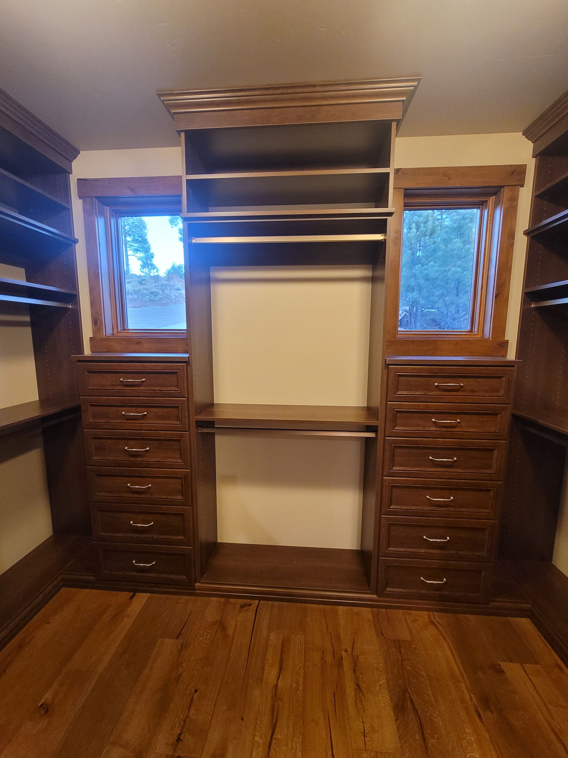 Built-in wooden hutch with glass-front cabinets, countertop, and drawers in a closet-like alcove