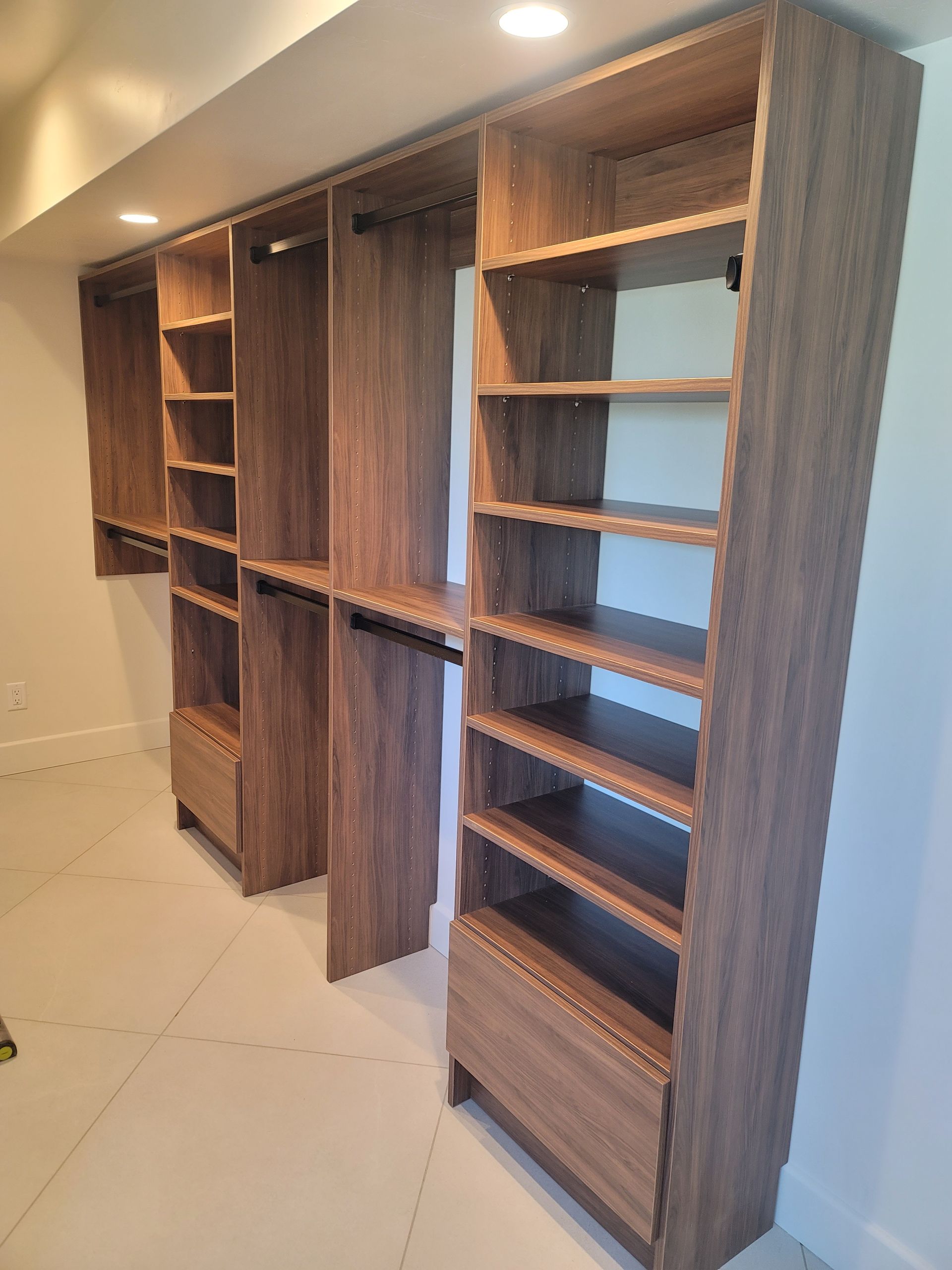 Built-in wood shelving and cabinets along a hallway wall, with open shelves and recessed niches.