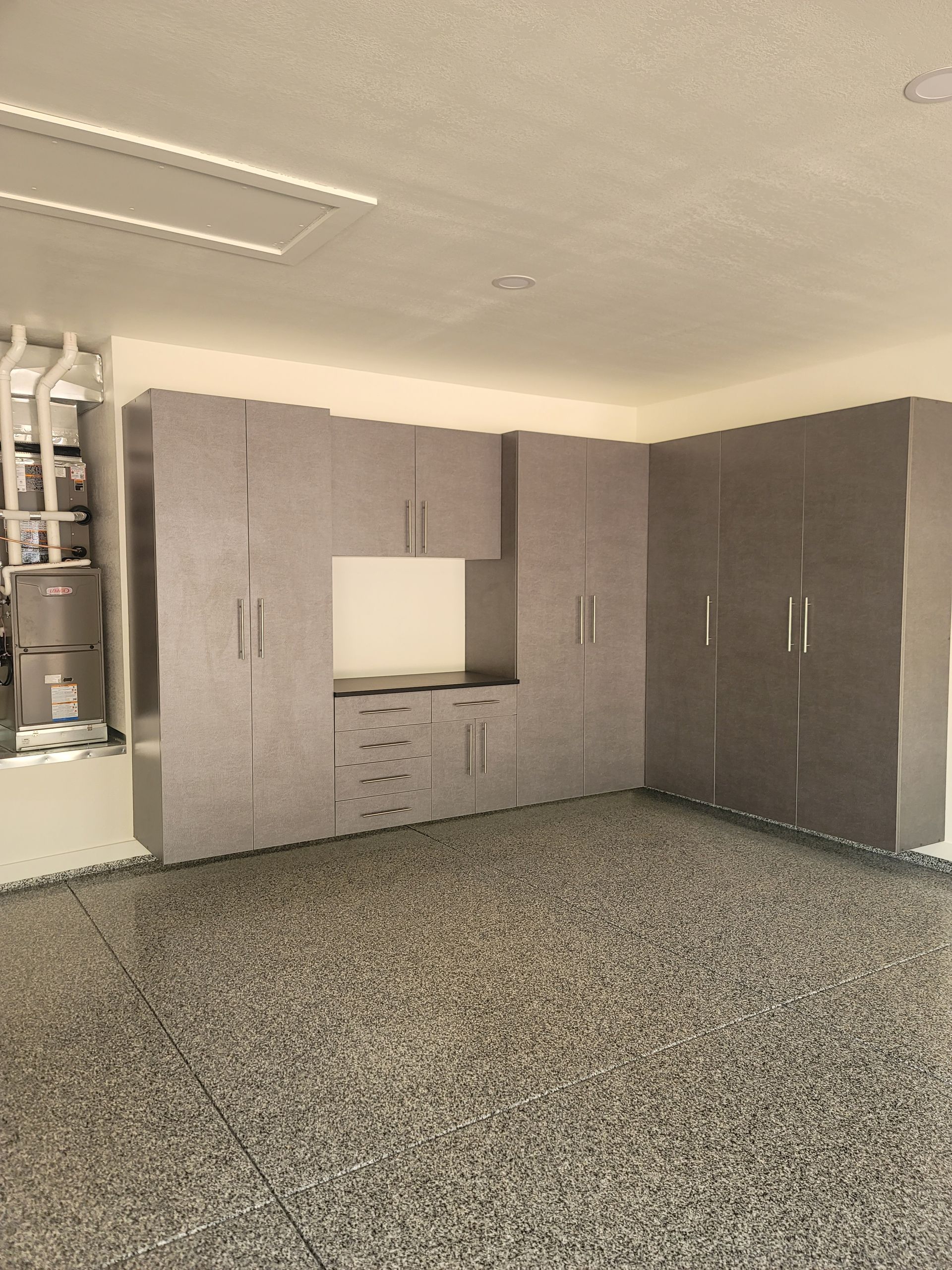 Empty room with built-in gray cabinets, a carpeted floor, and a small window opening.