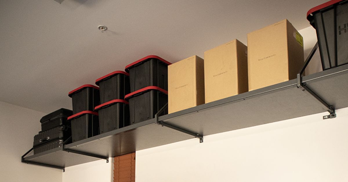 Shelves with black storage bins and brown cardboard boxes mounted high on a wall