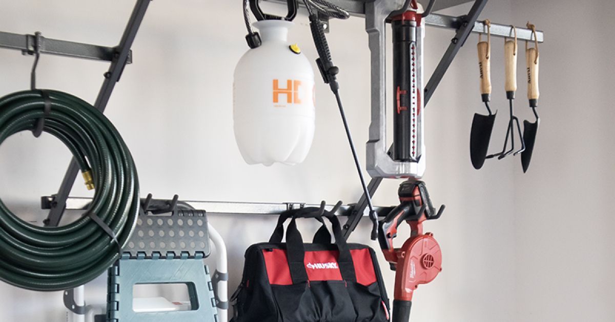 Garage wall with hanging tools, hoses, and bags organized on hooks and shelves