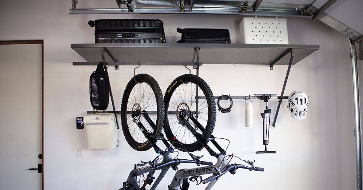 Garage wall with hanging bicycles, tools, and storage shelves above.
