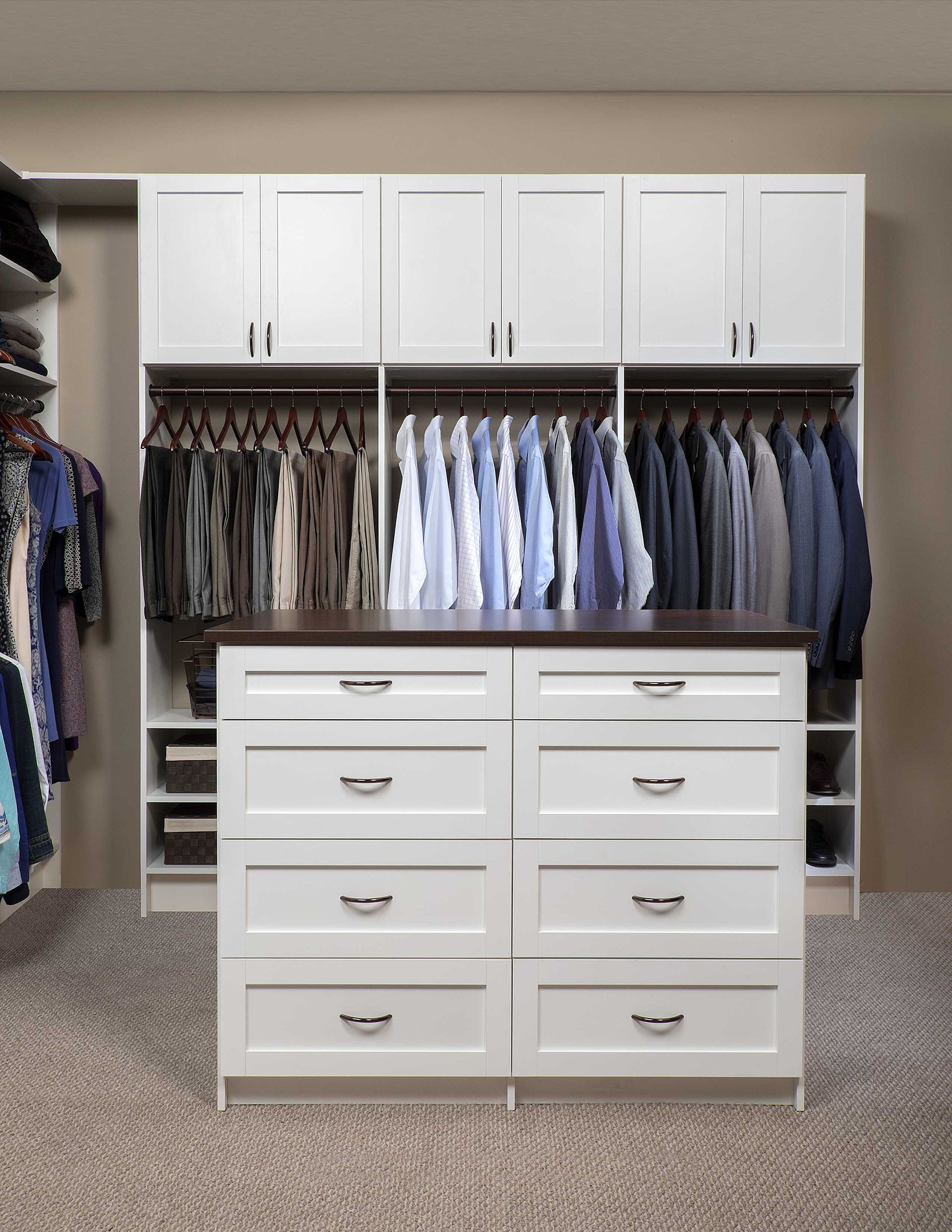White closet with hanging shirts and jackets above a white eight-drawer dresser in a bedroom.