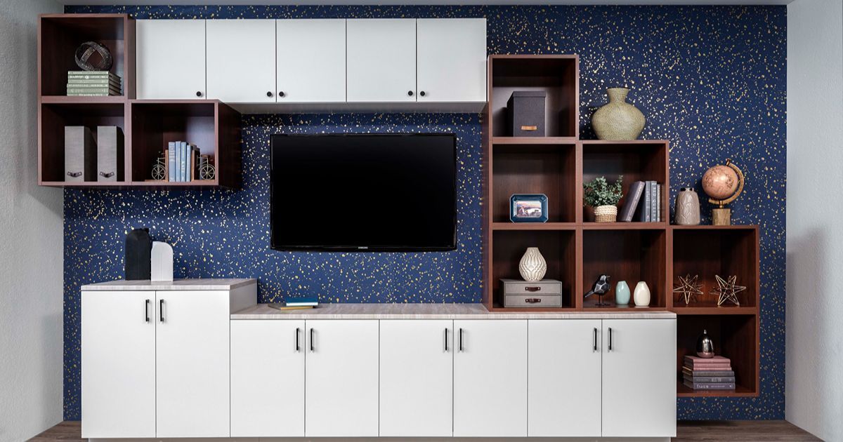 Modern living room wall unit with white cabinets, wood shelves, and a TV against a blue patterned wall