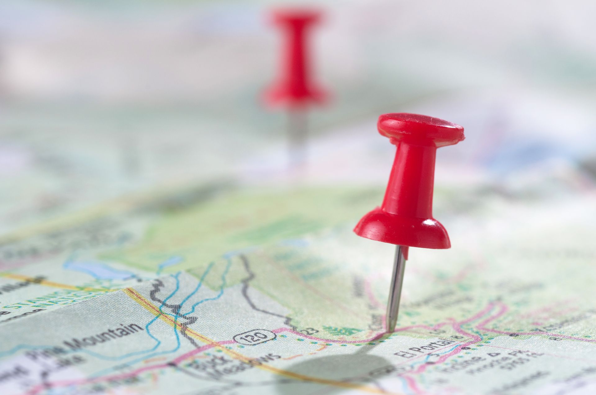 A close up of a red pin on a map.