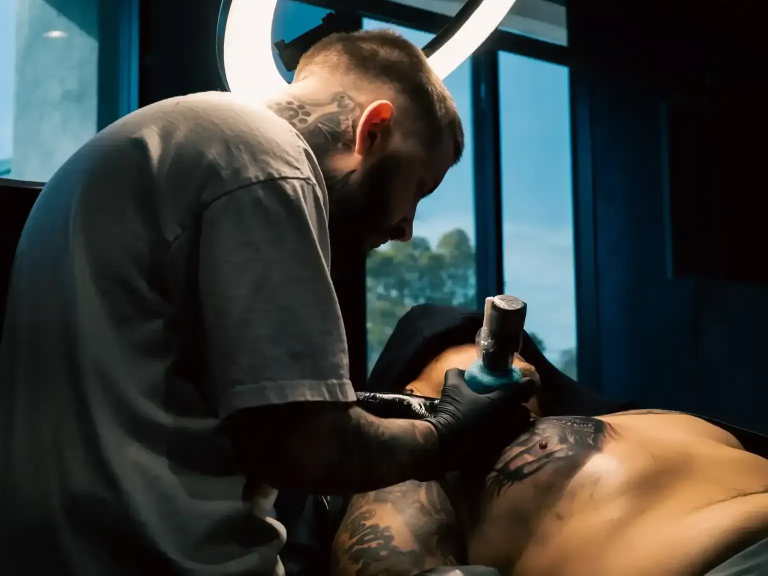 Mickey tattooing a pectoral tattoo piece 