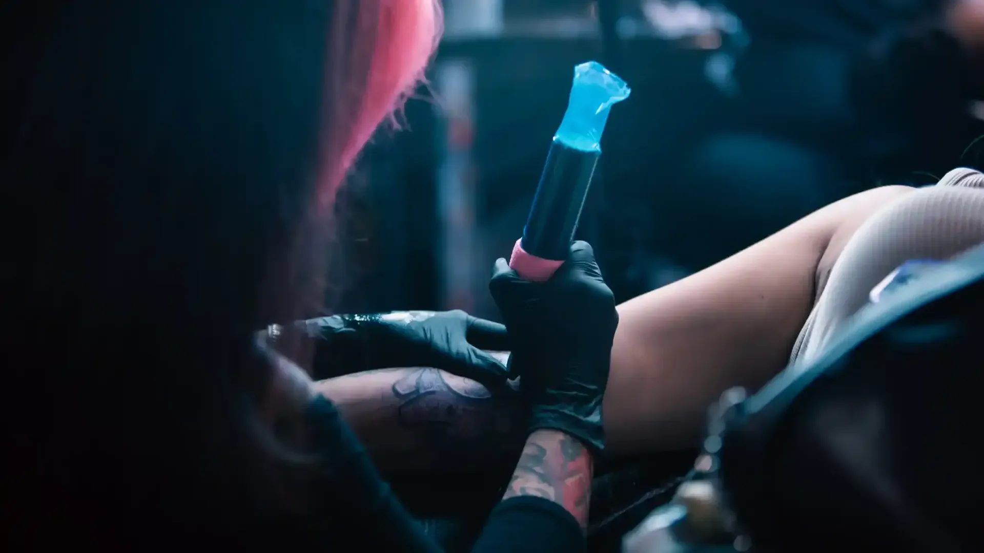 a tattoo artist drawing a design on a client's arm with a sharpie 