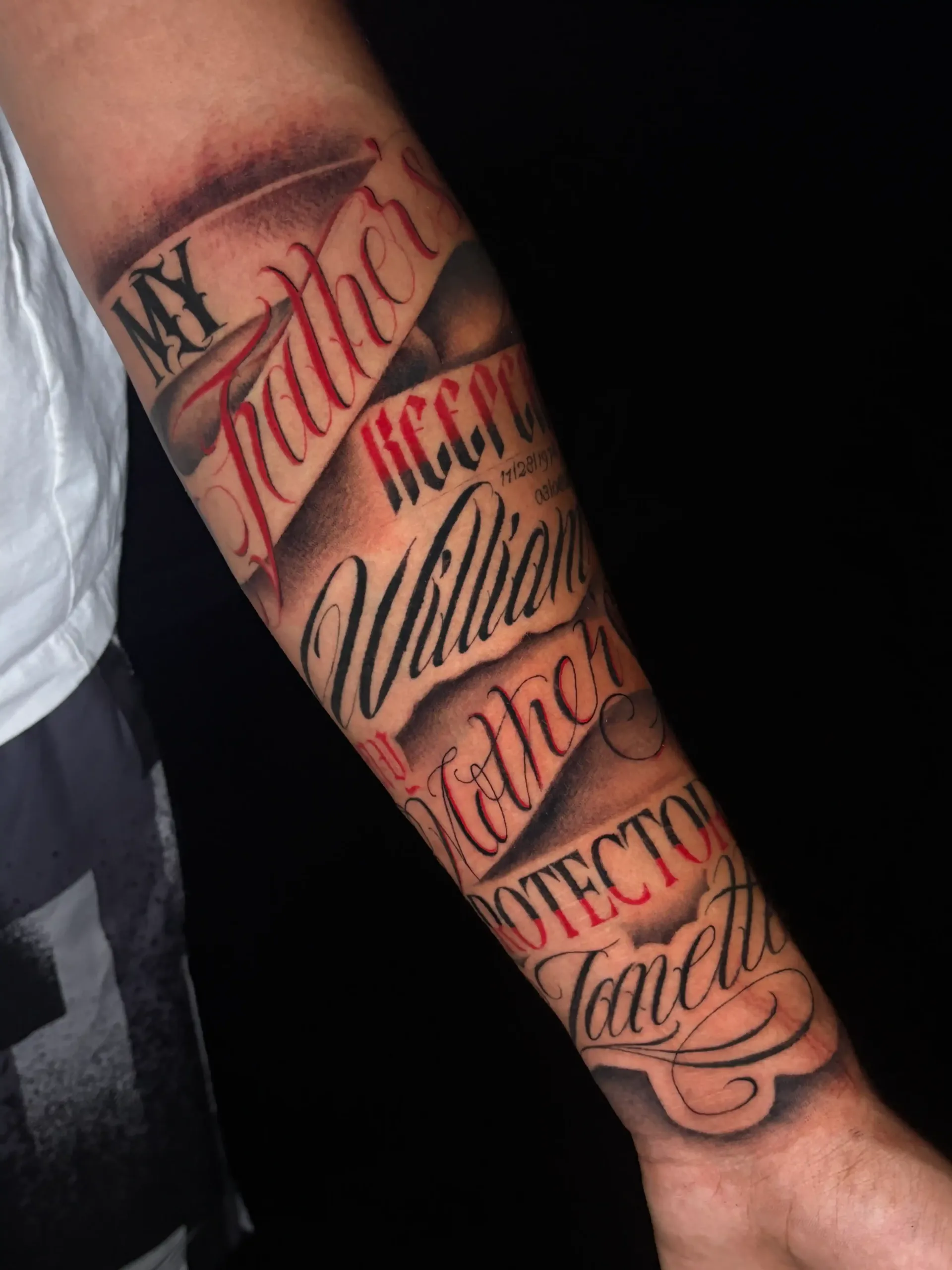 arm tattoo with black and red script