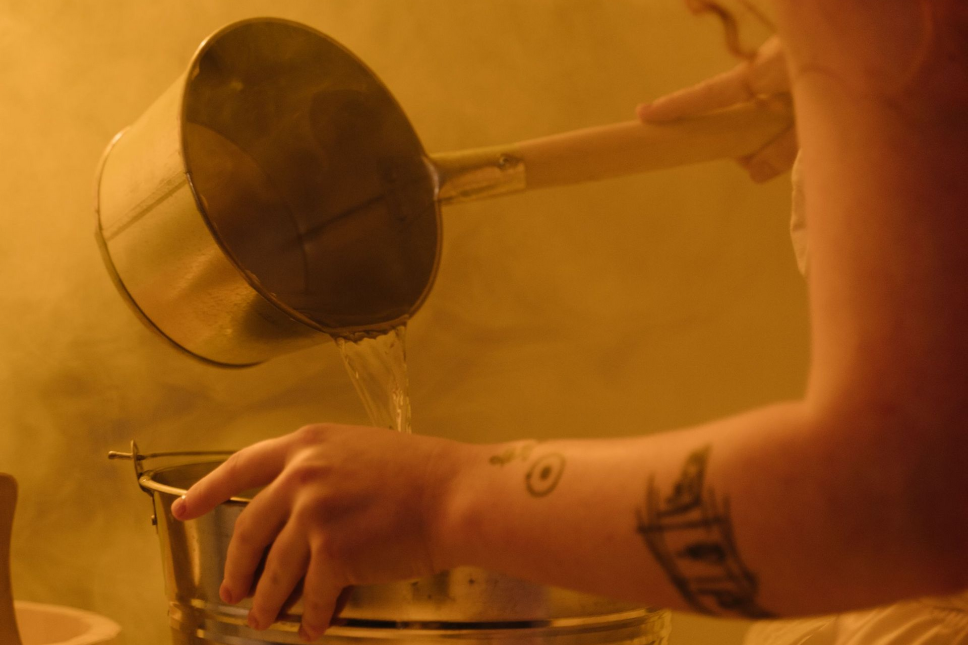 person with healing tattoos in a sauna