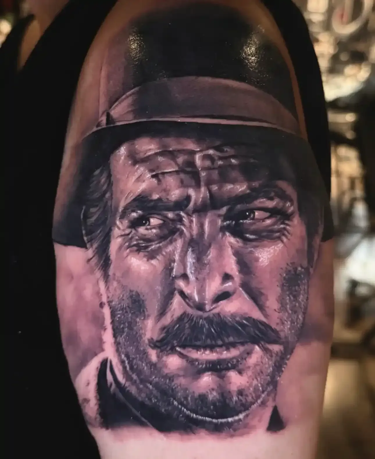 Black and grey portrait tattoo on upper arm showing clarity
