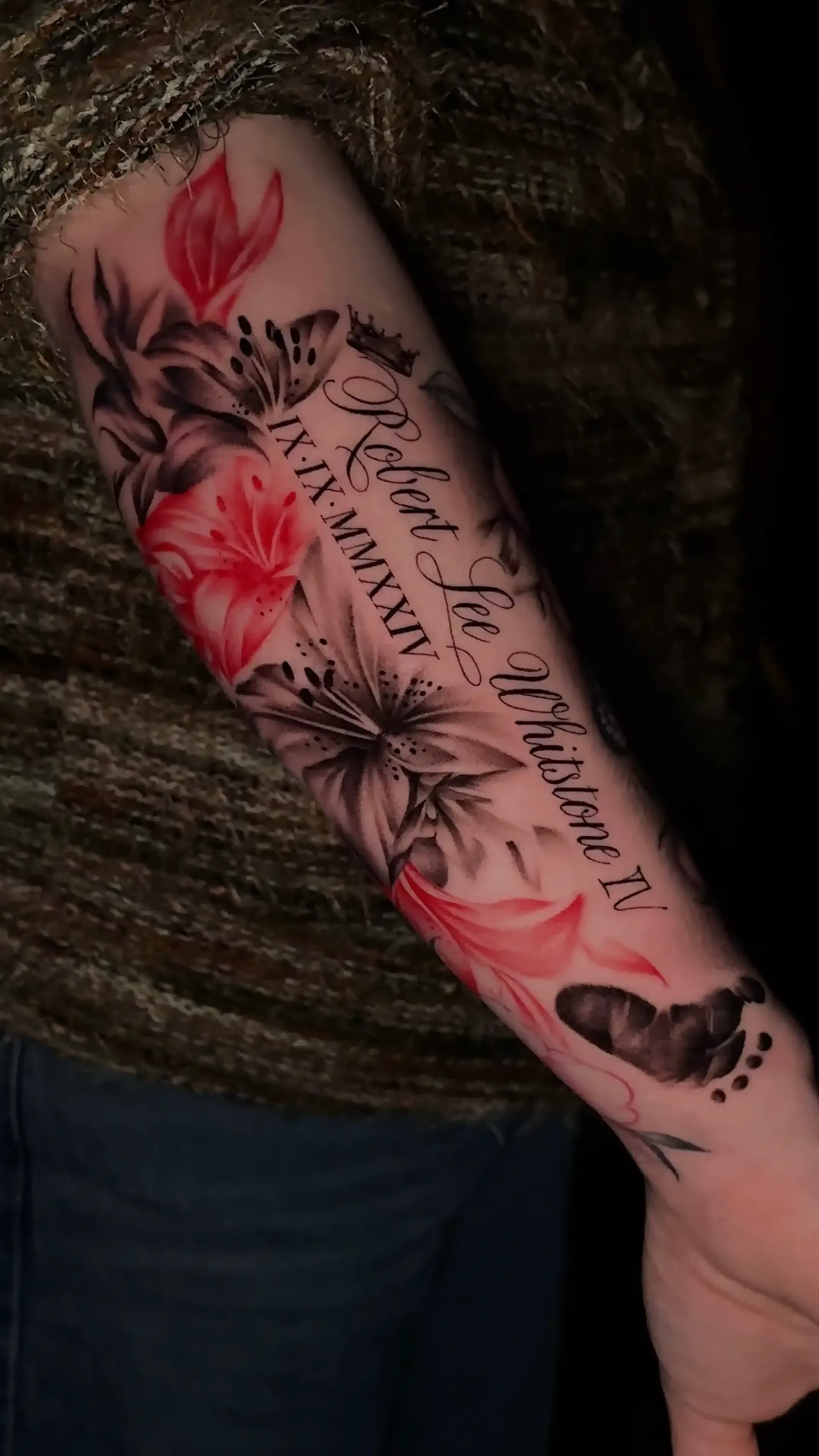 black and red floral and script tattoo on a forearm 