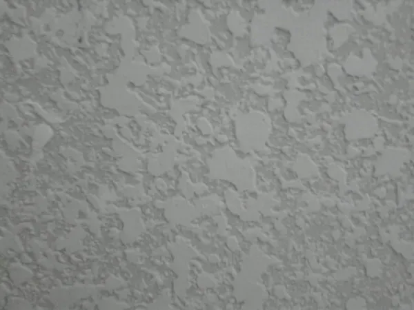 Close-up of gray textured wallpaper with a subtle floral pattern.