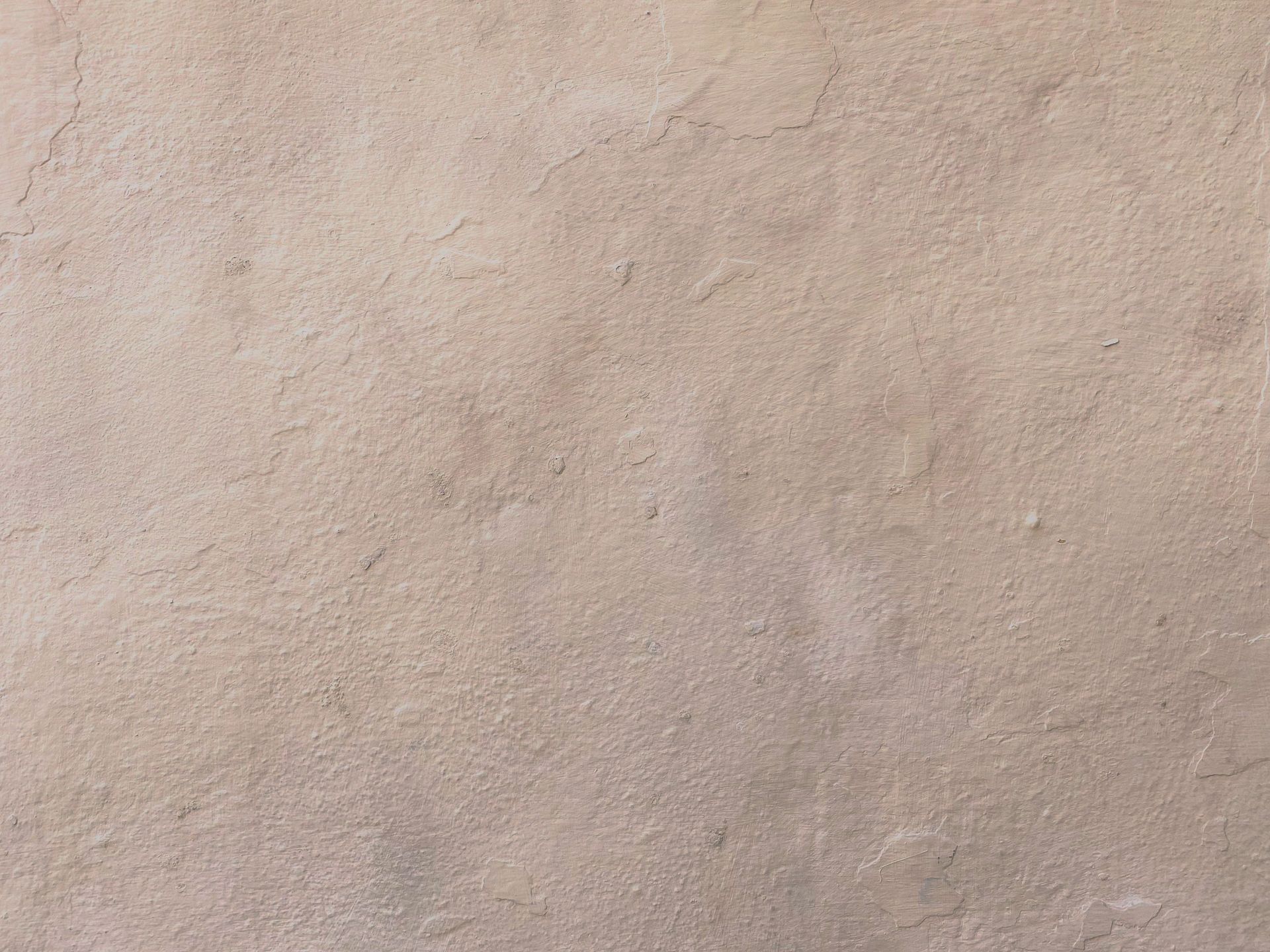 Close-up of a beige textured wall with subtle mottling and small imperfections