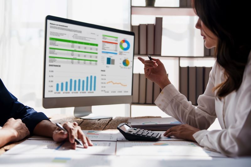 Two people looking at a computer with accounting software | Featured image for the Business Services page for Rudd Mantell Accountants
