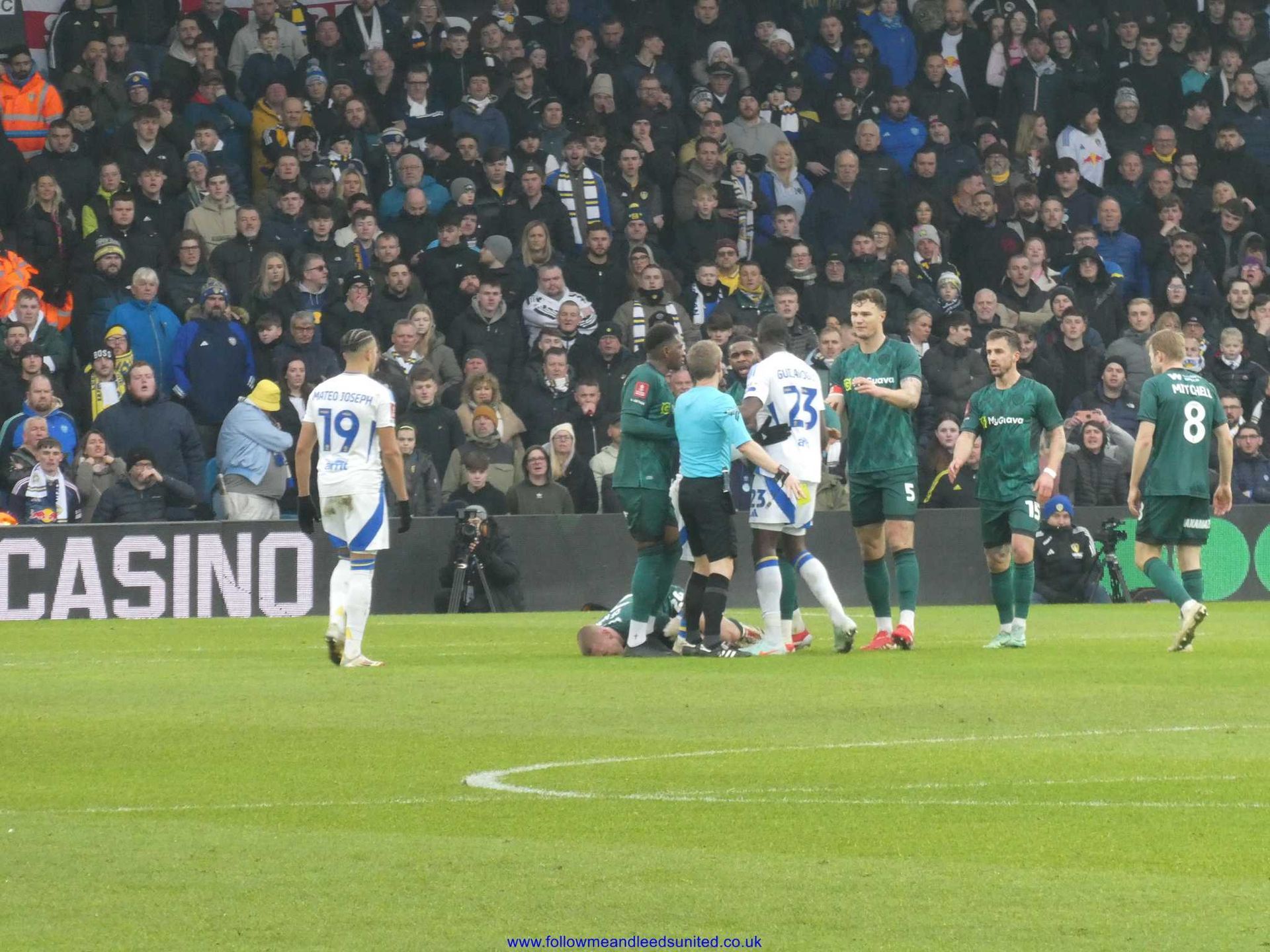 Leeds United and Millwall players on a field during the FA Cup tie in February 2025 at Elland Road with a casino sign in the background