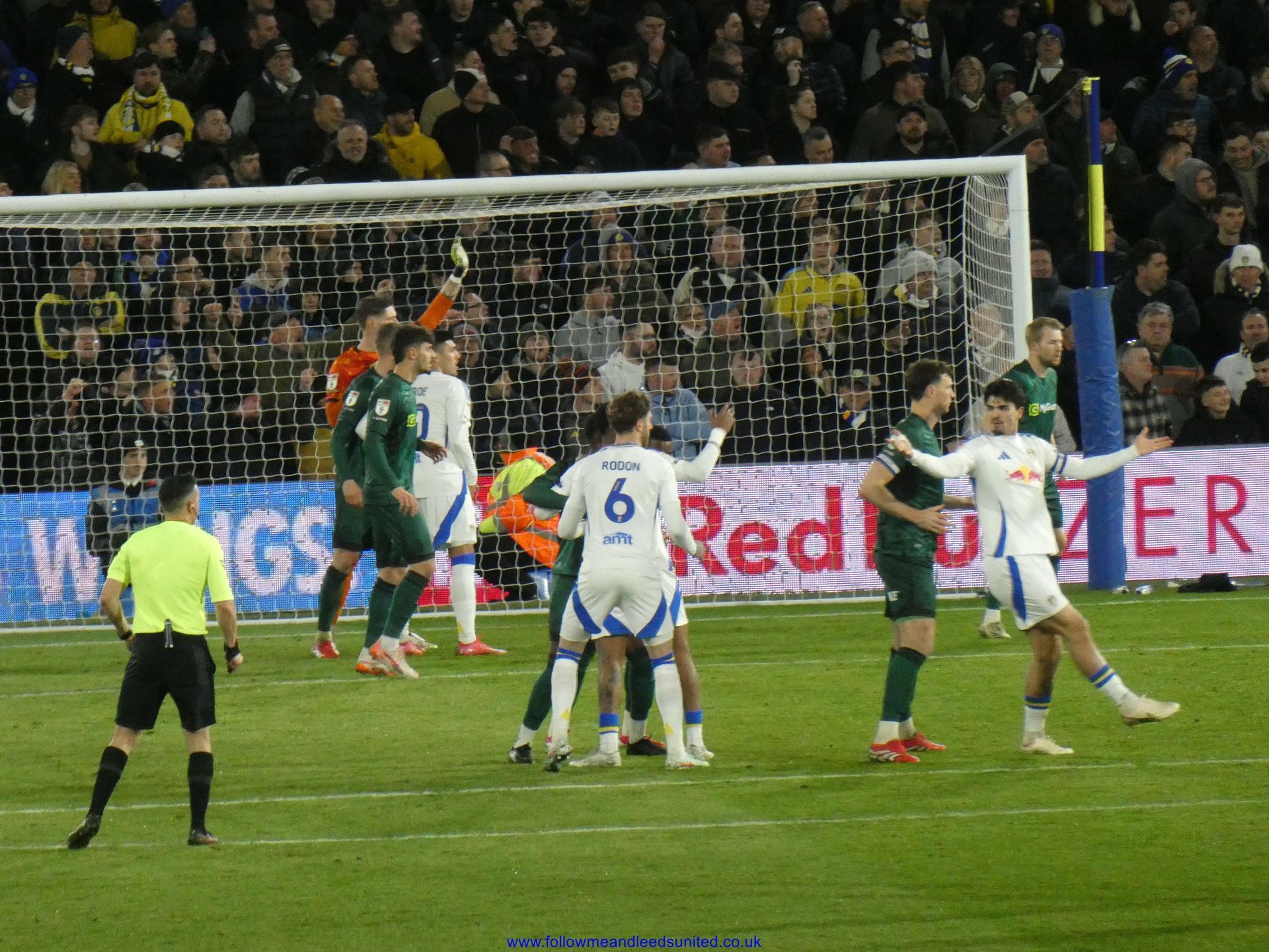 A group of football players on a field with a red bull ad in the background - Leeds vs Millwall - March 2025