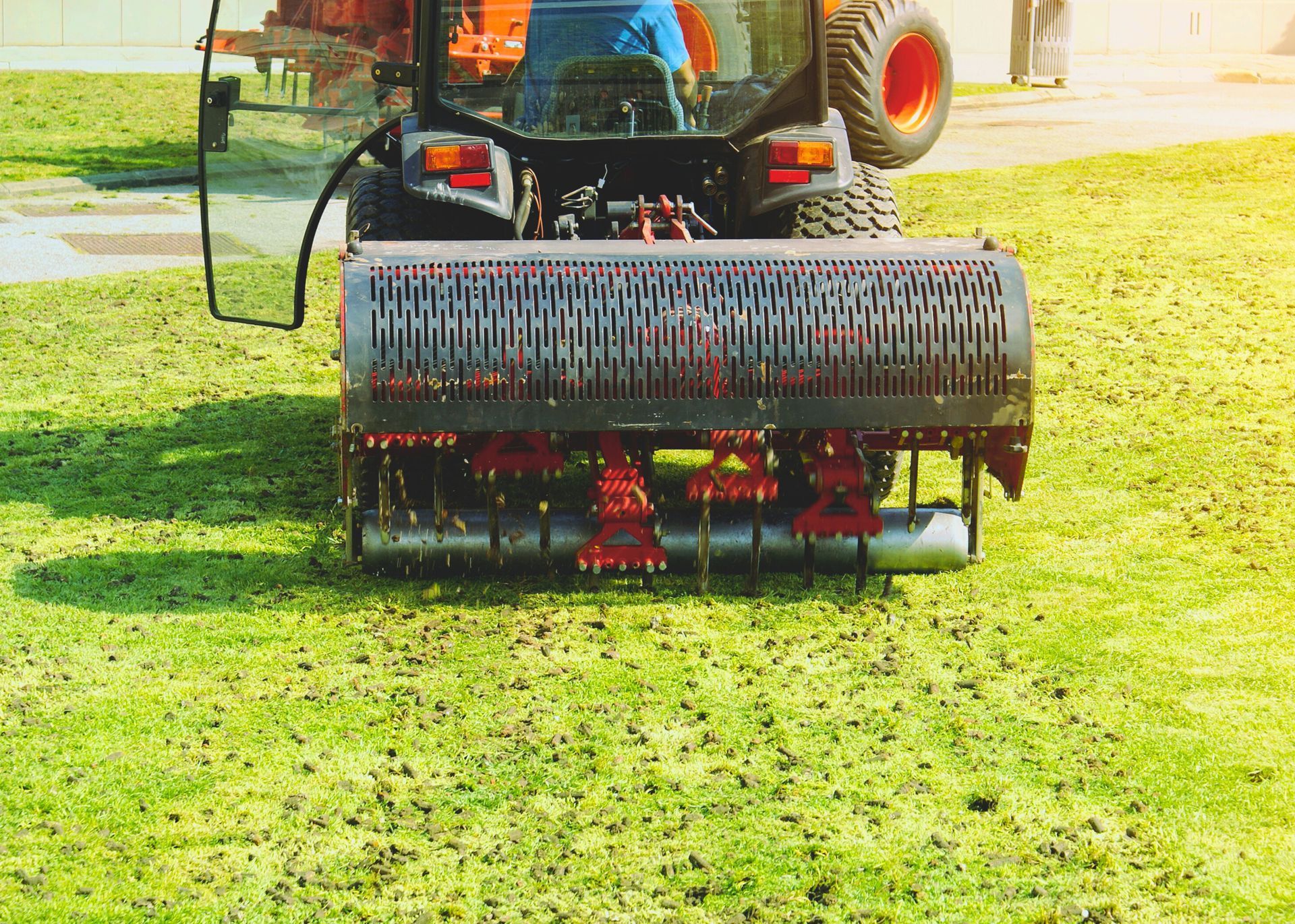 A tractor is aerating a lush green lawn in Gurnee, IL.