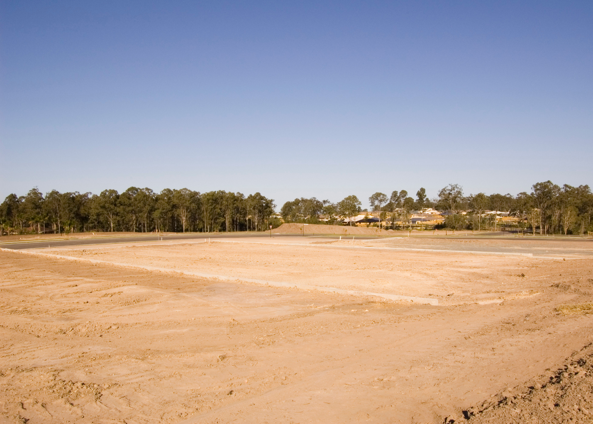 A perfectly graded piece of ground at a wide-open construction site.