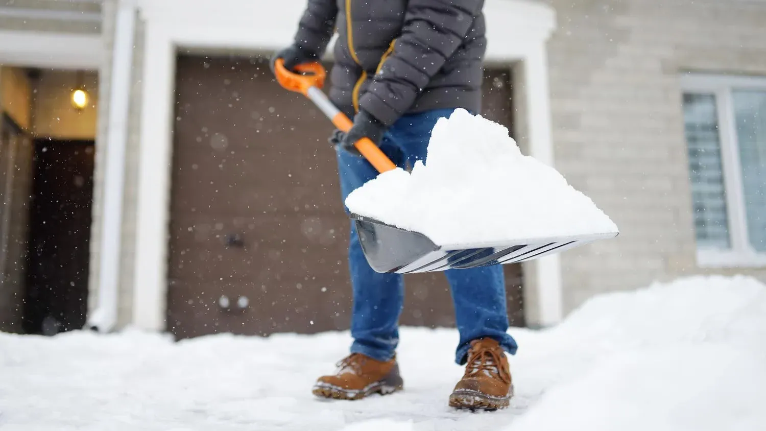 Shoveling snow in front of a house