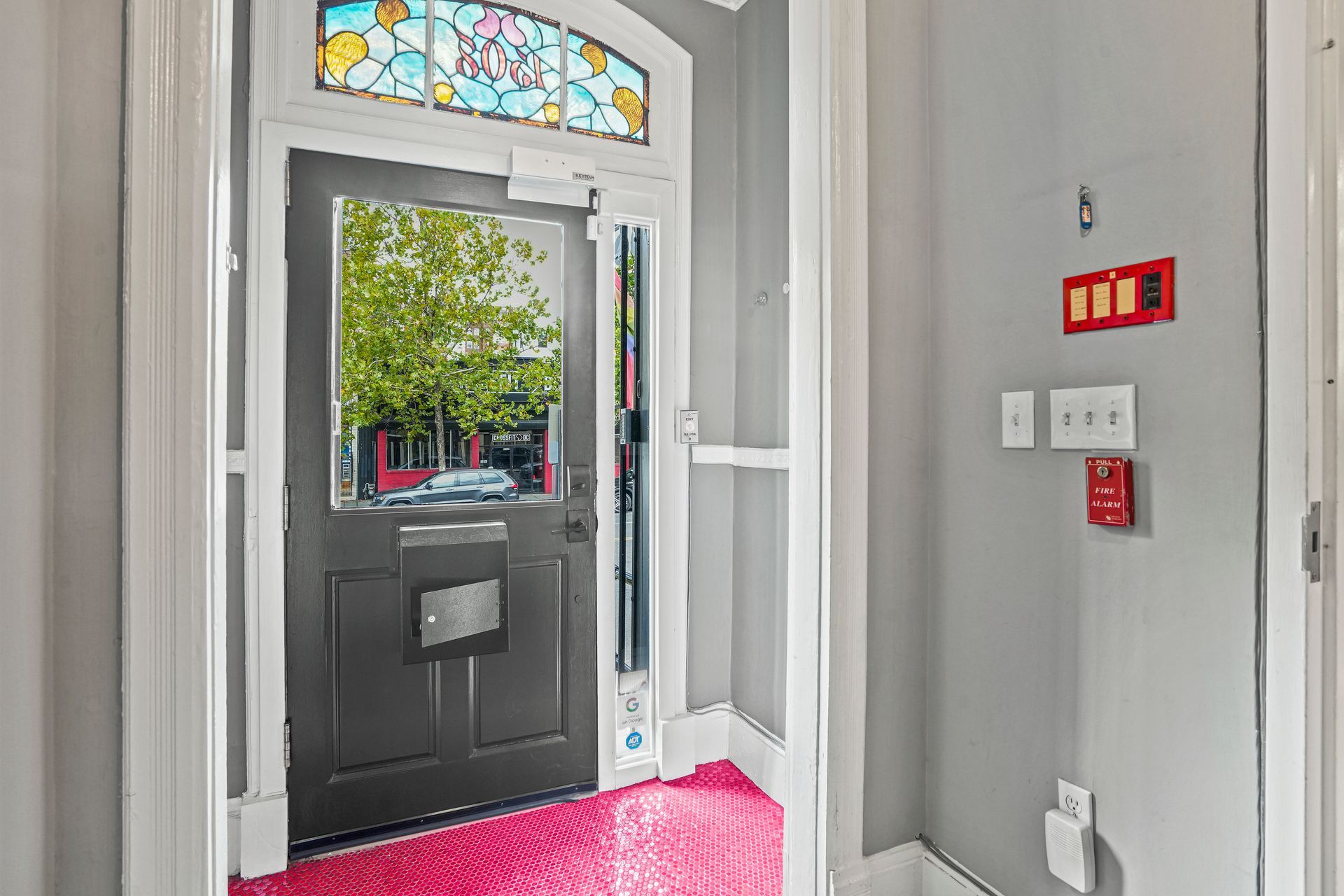 Building entrance lobby with glass door and pink accent flooring