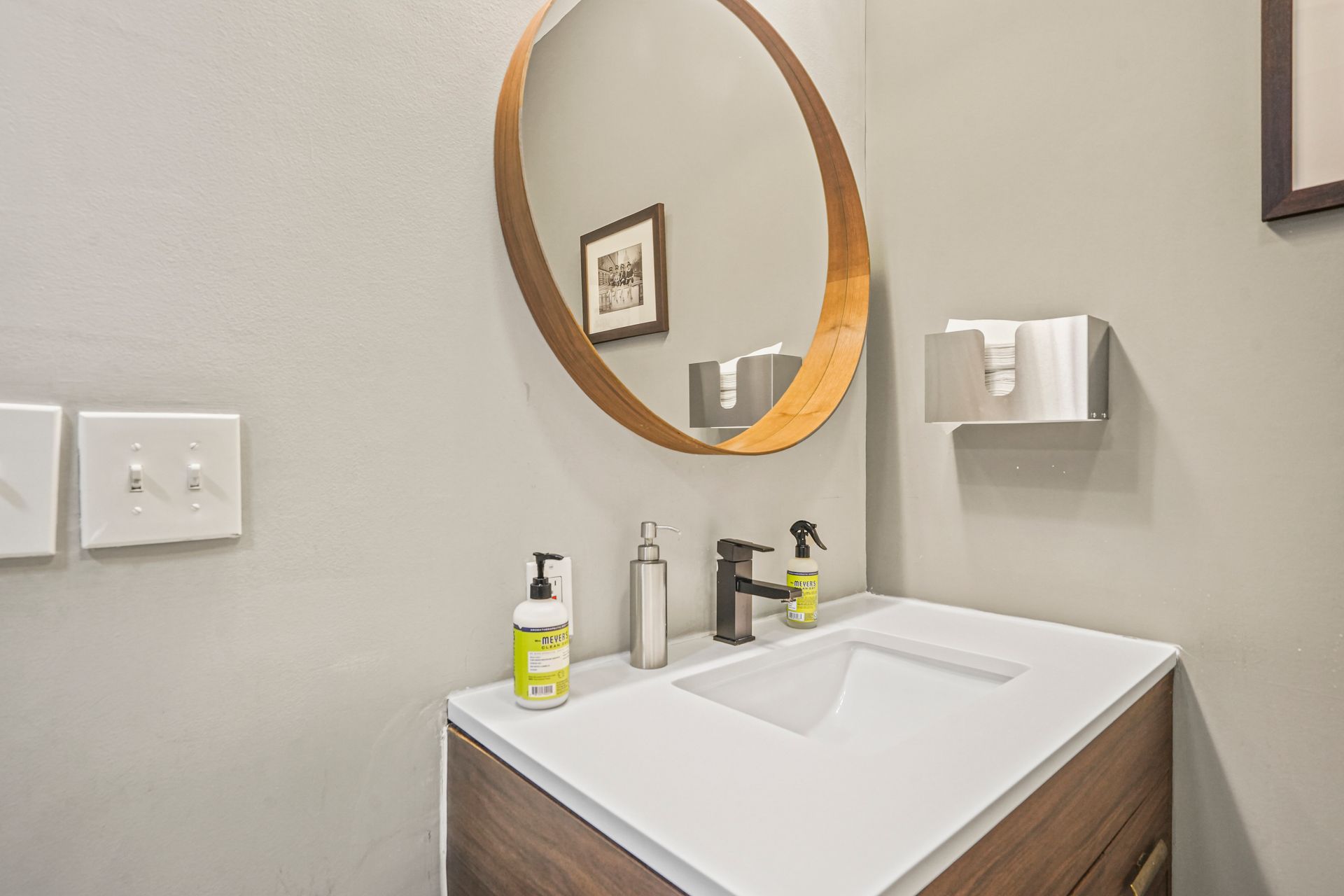 Modern restroom vanity with round mirror and sink