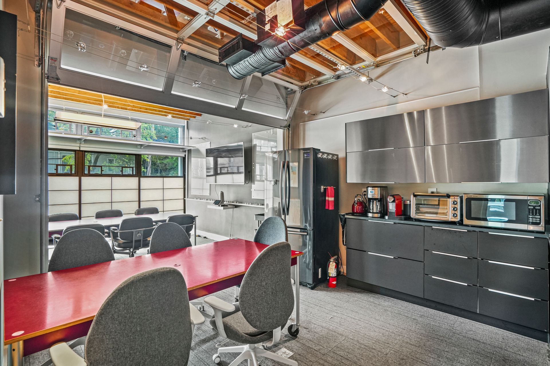 Collaborative office area with desks and exposed industrial ceiling