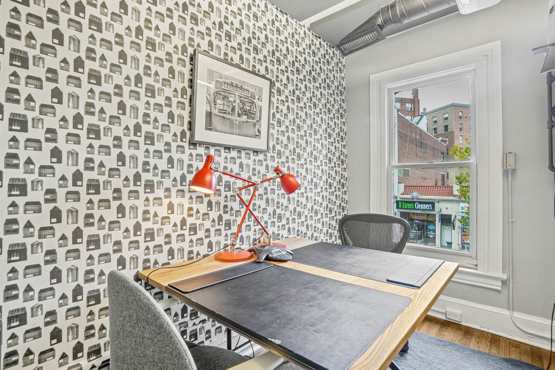 Small meeting room with patterned wallpaper and table seating
