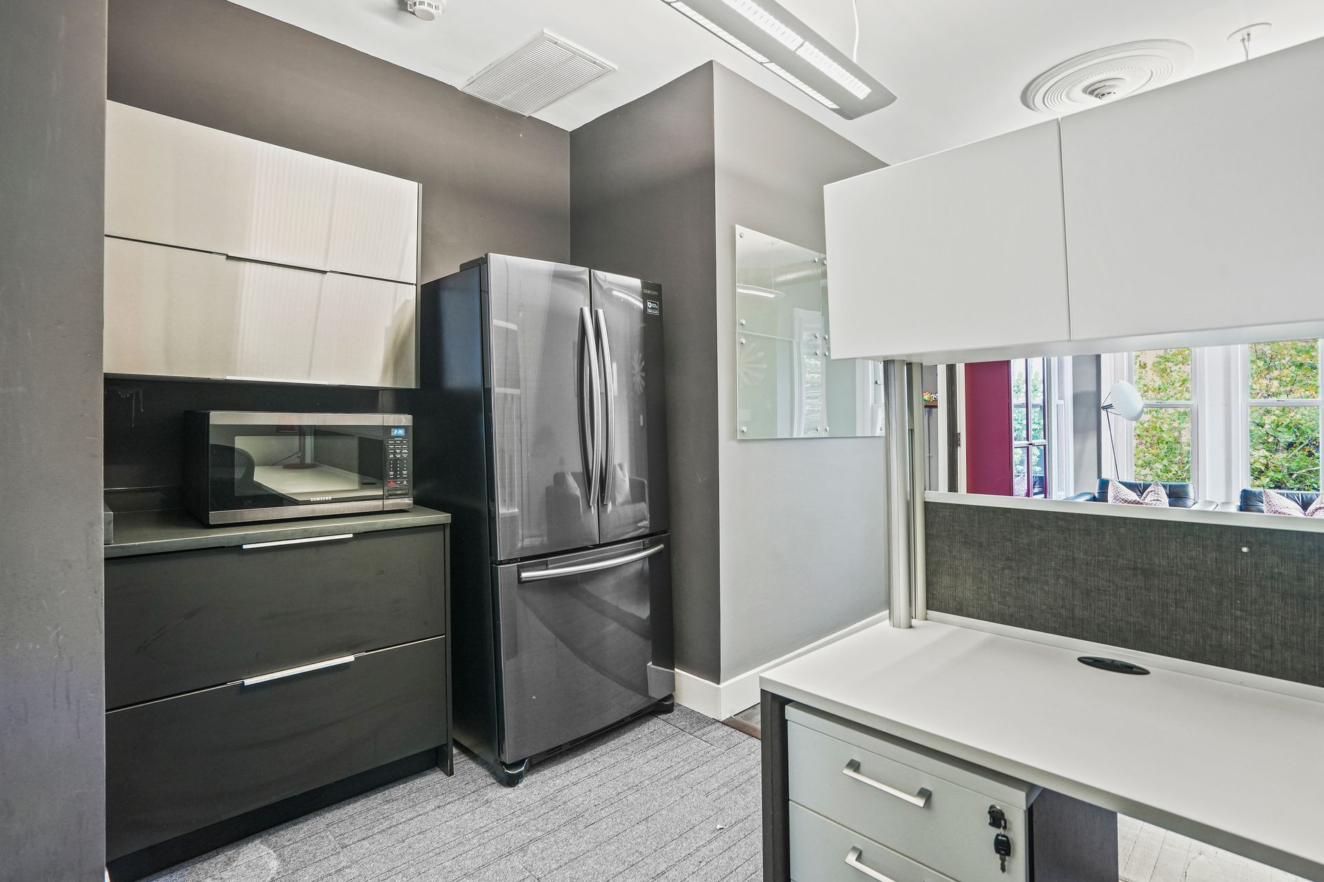 Kitchenette with black refrigerator and modern cabinetry
