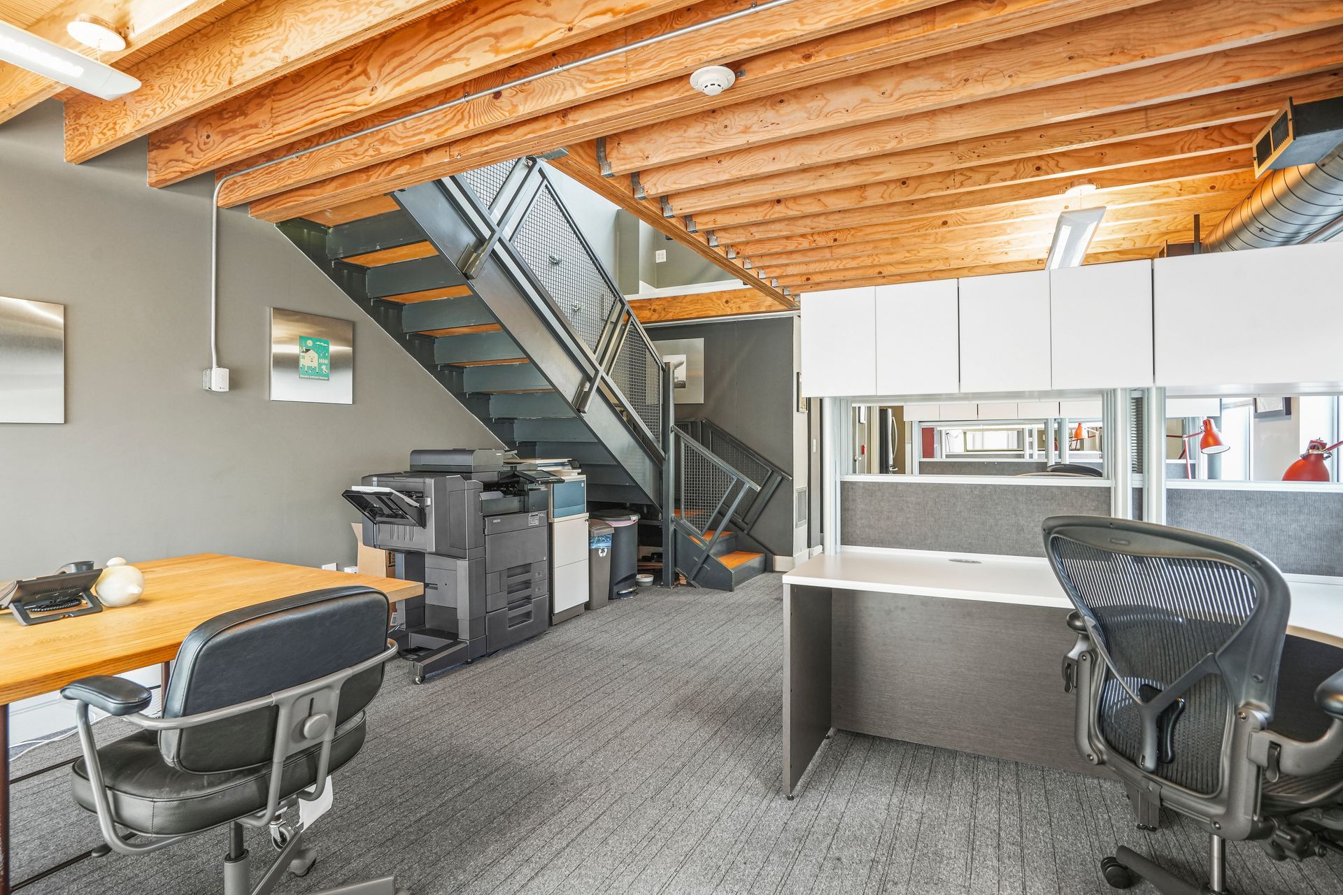Open office workspace with cubicles and exposed ceiling design