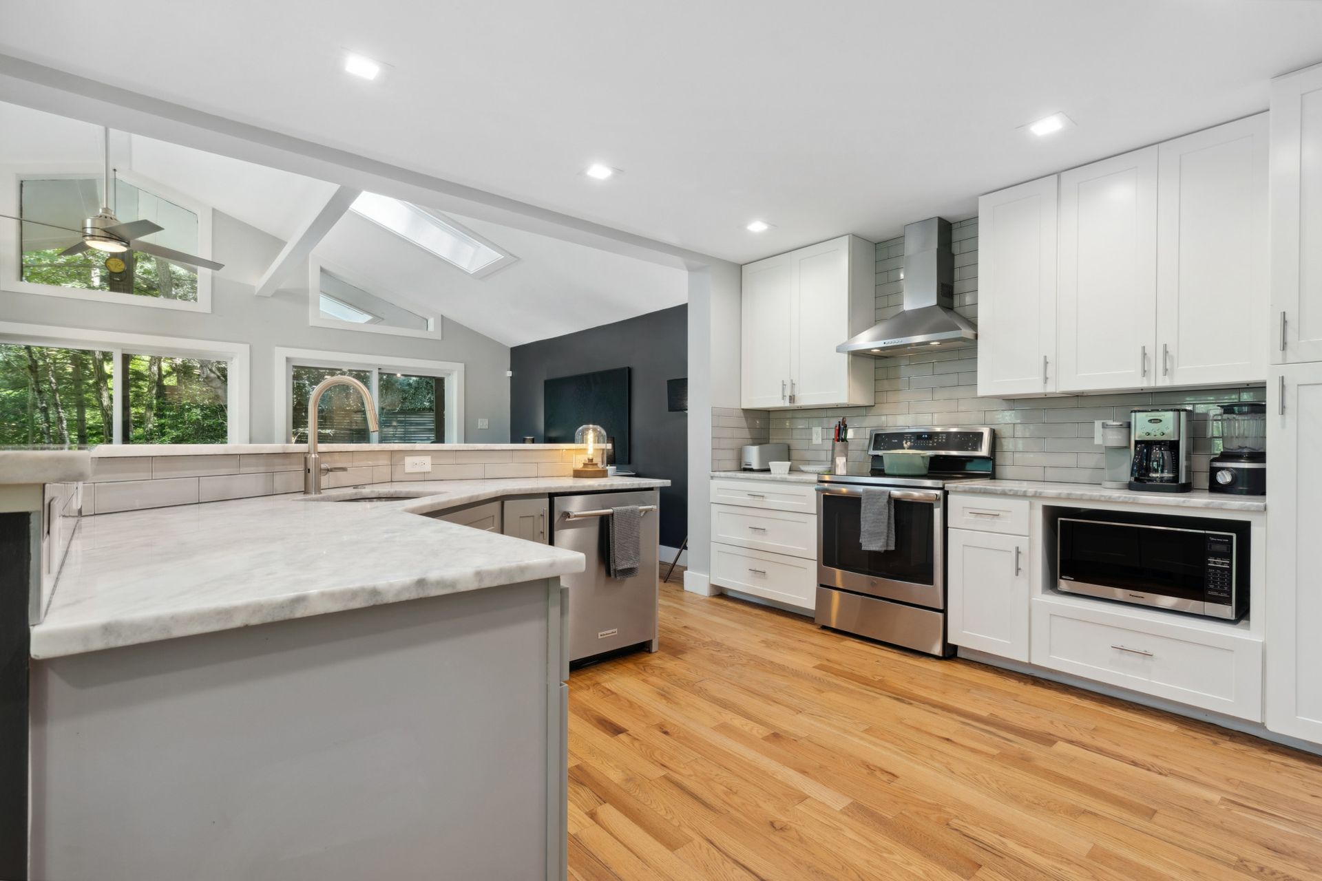 Modern white kitchen with large island and wood flooring