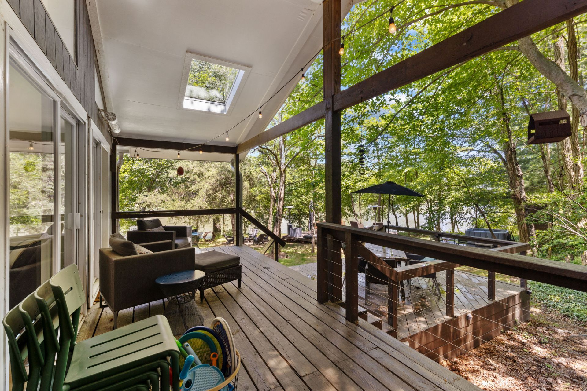 Outdoor patio lounge with seating beneath mature trees