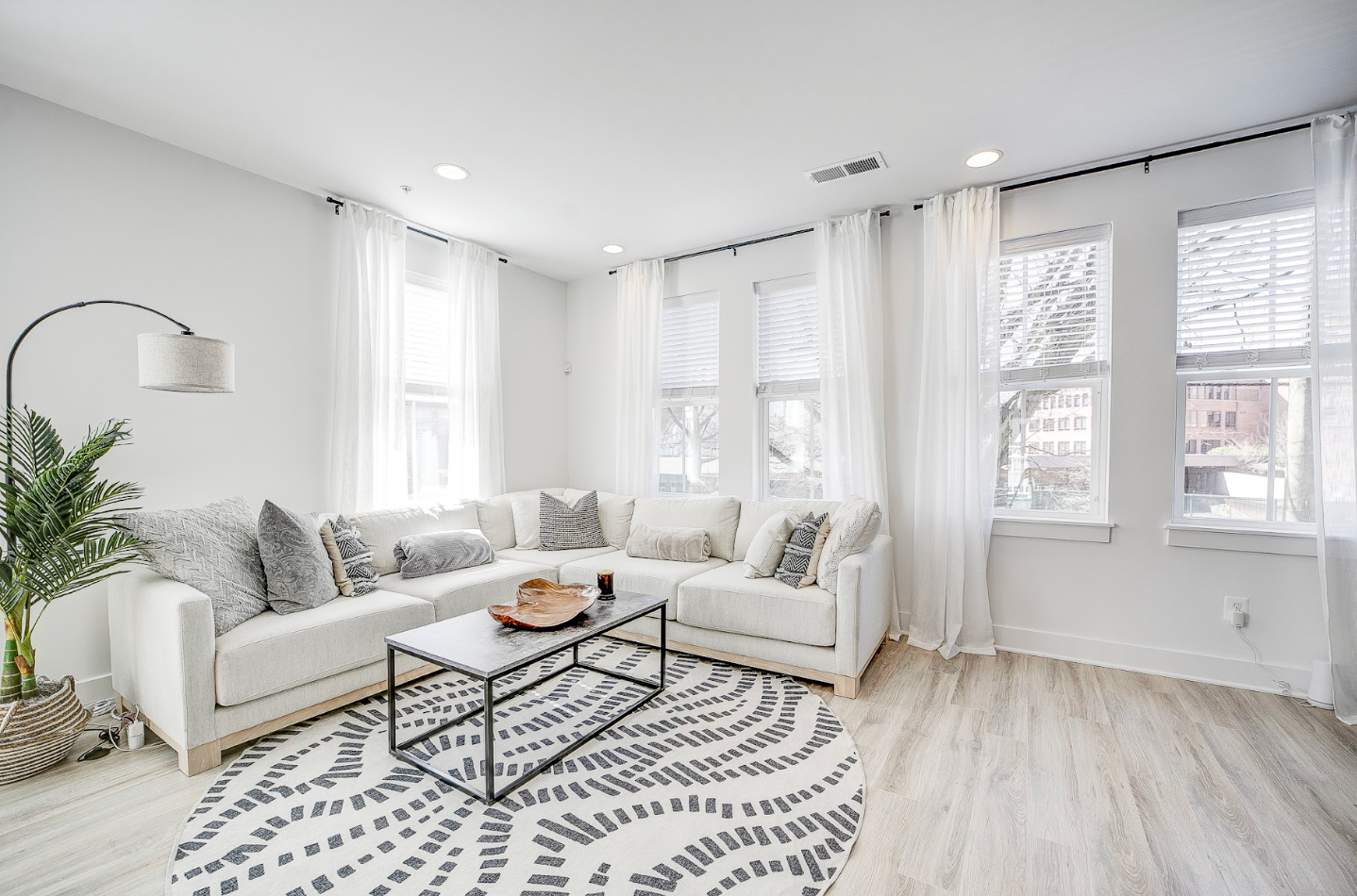 Bright apartment living room with large windows and decor