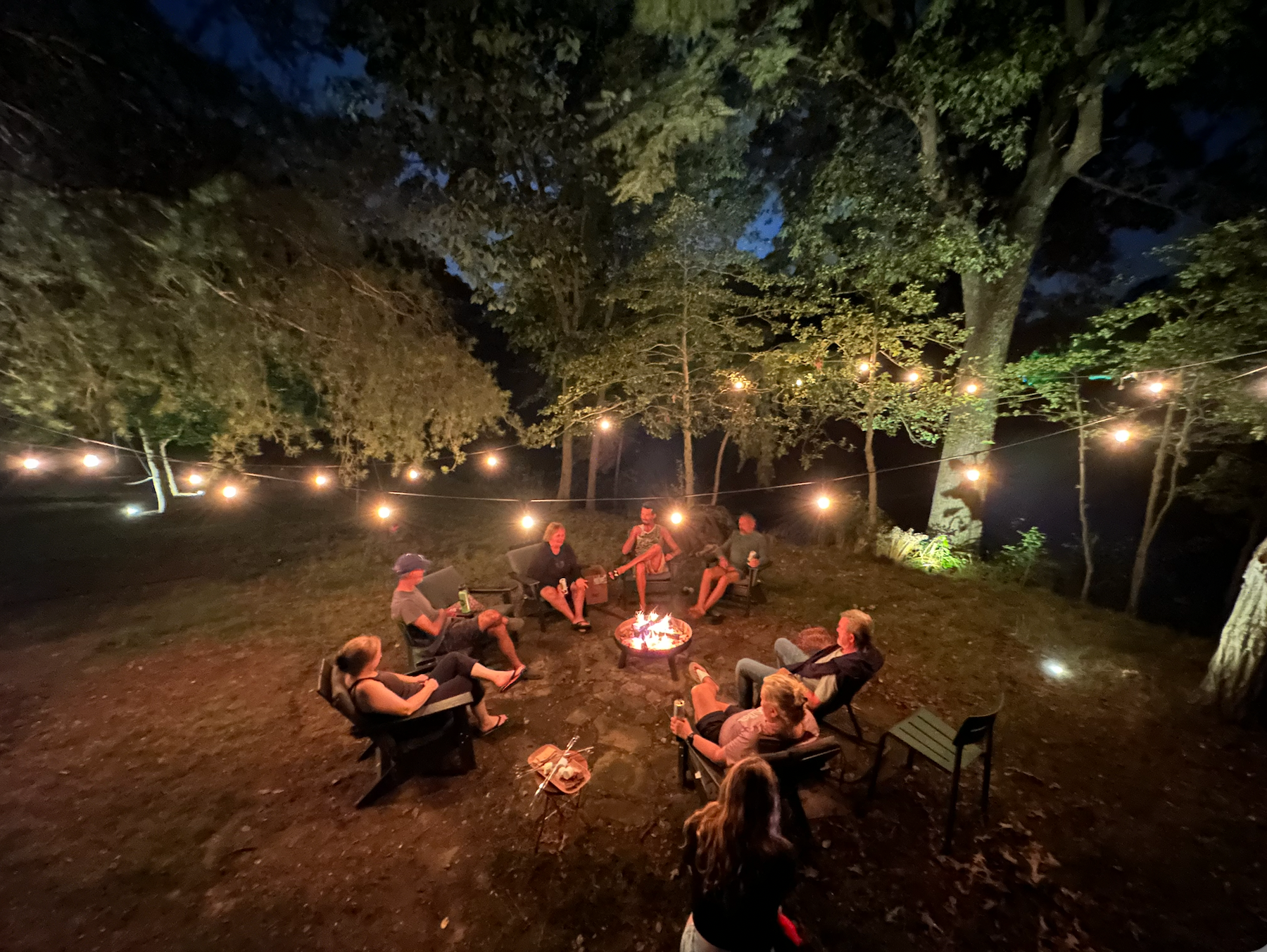 Evening outdoor community event with string lights and seating