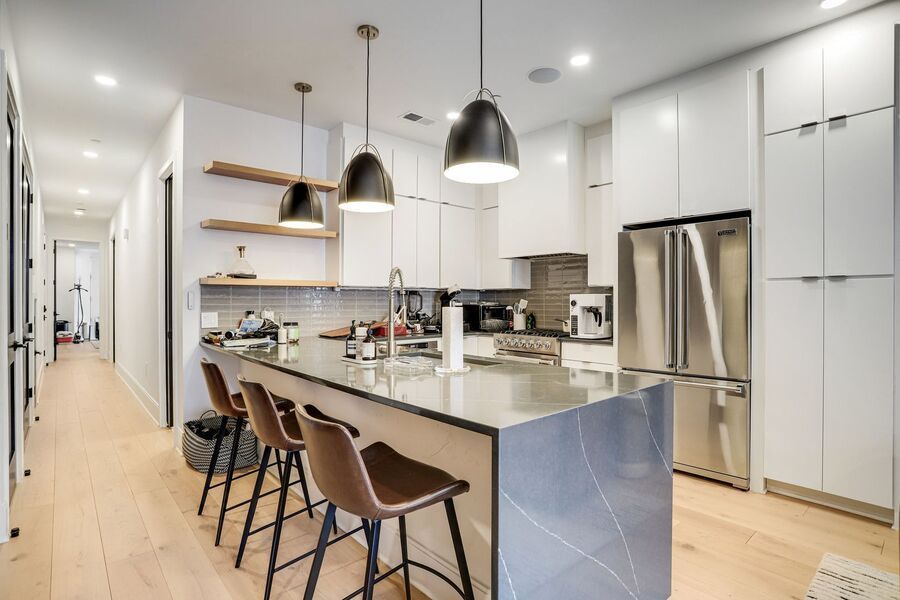 newly renovated DC rental kitchen with light cabinets and big light fixtures