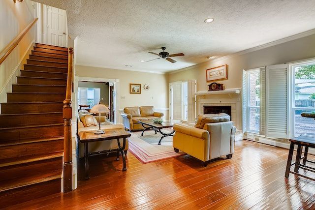 living room with fireplace, staircase white chair and two sofas with wood floors and patio doors