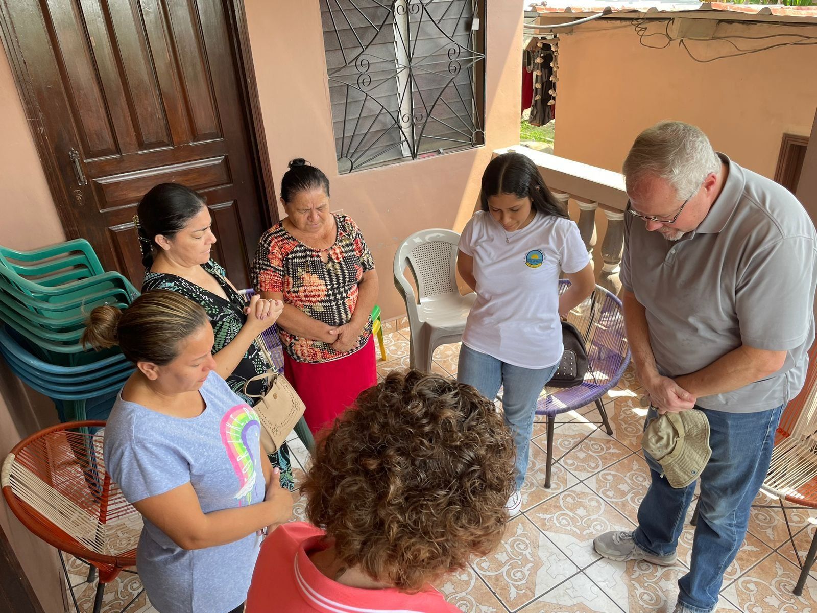 A group of people are standing in a circle talking to each other.