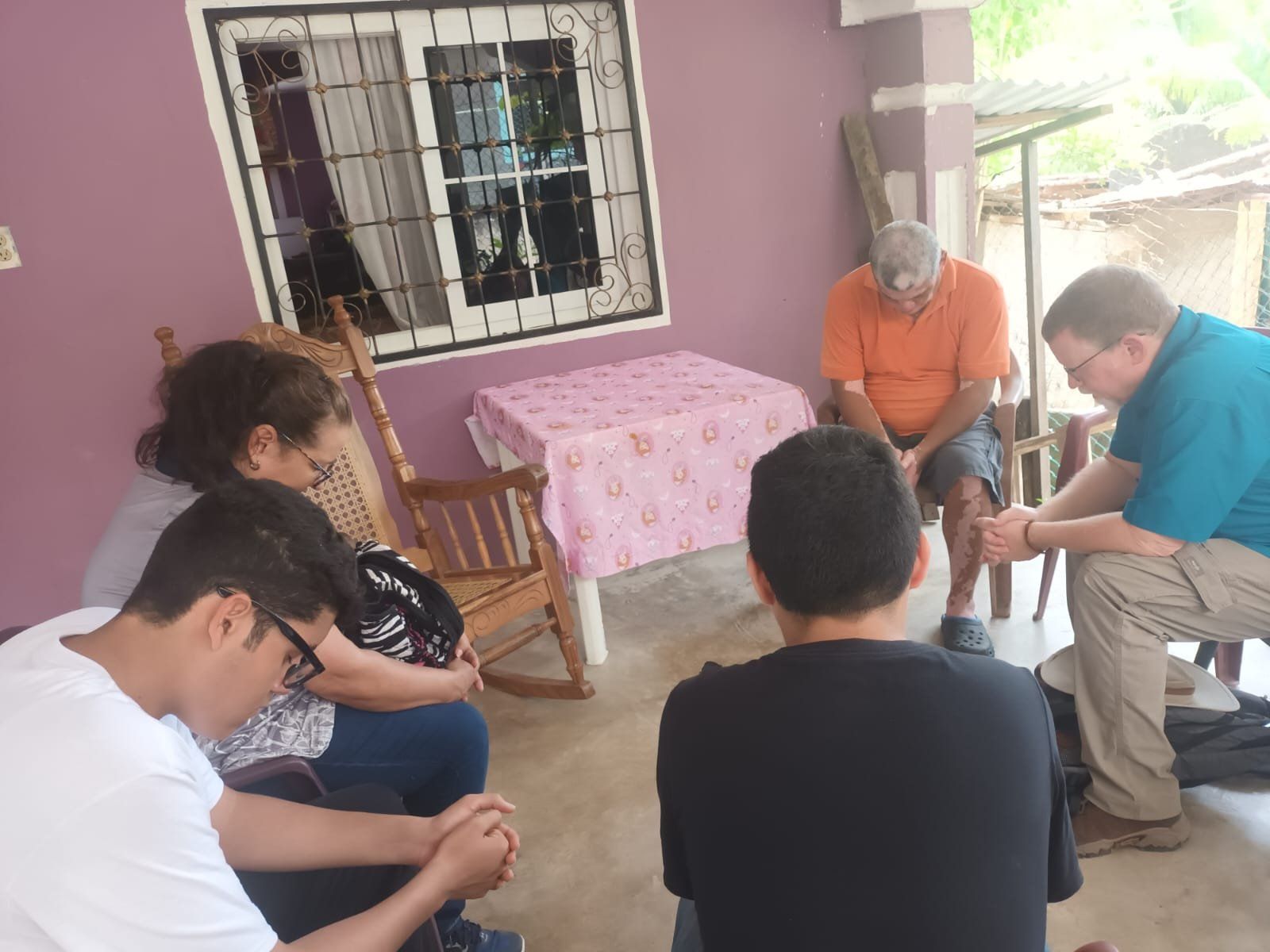 A group of people are sitting in a circle praying