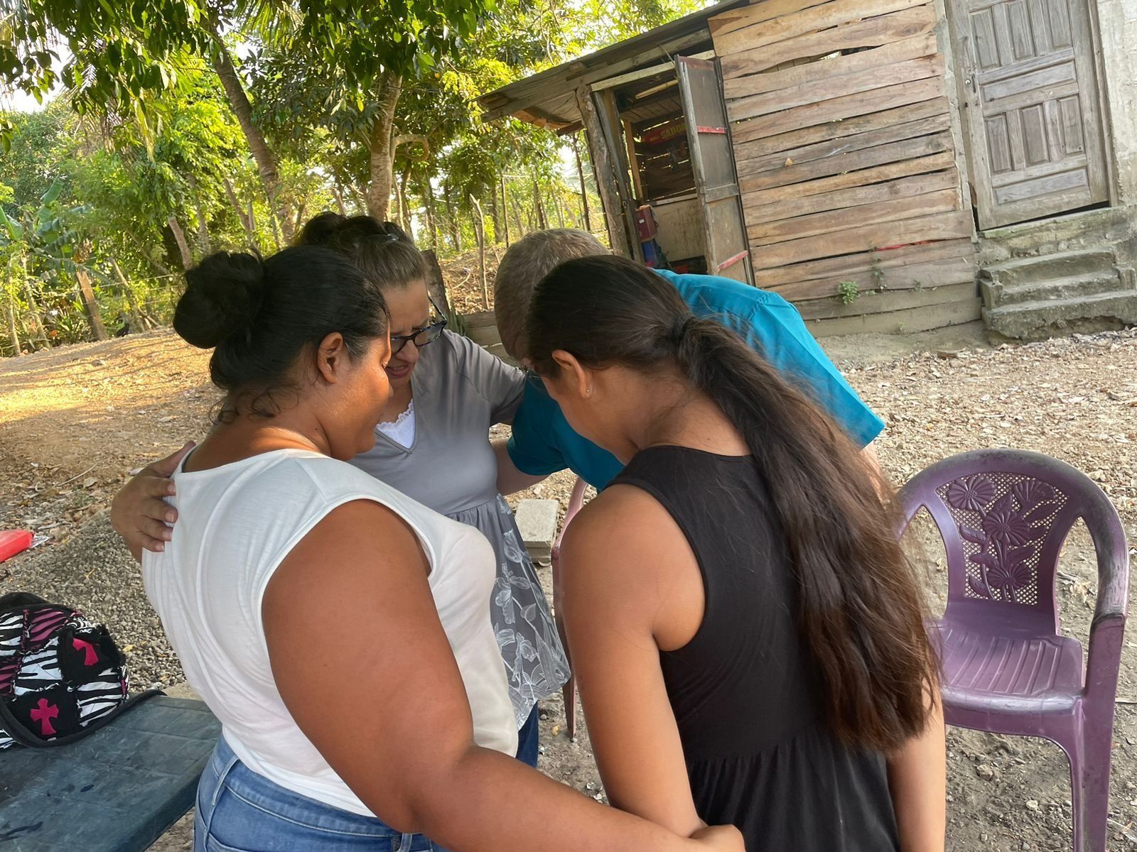A group of women are standing in a circle with their arms around each other.