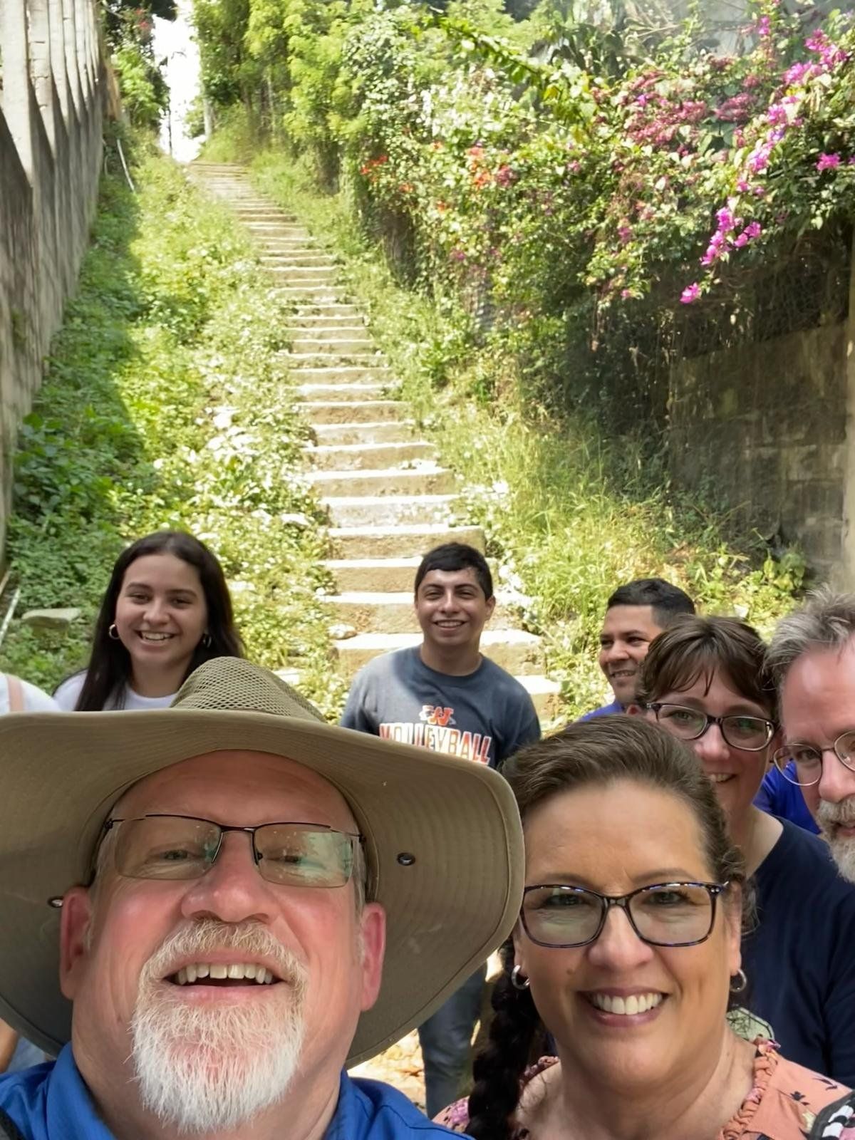A group of people are standing in front of a set of stairs.