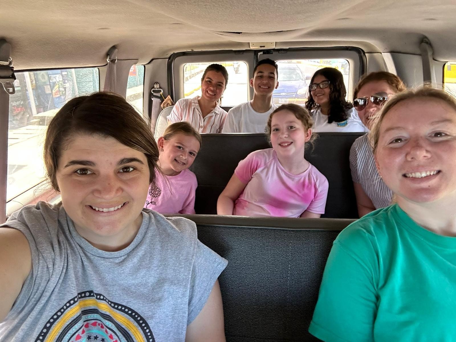 A group of people are sitting in the back of a van.
