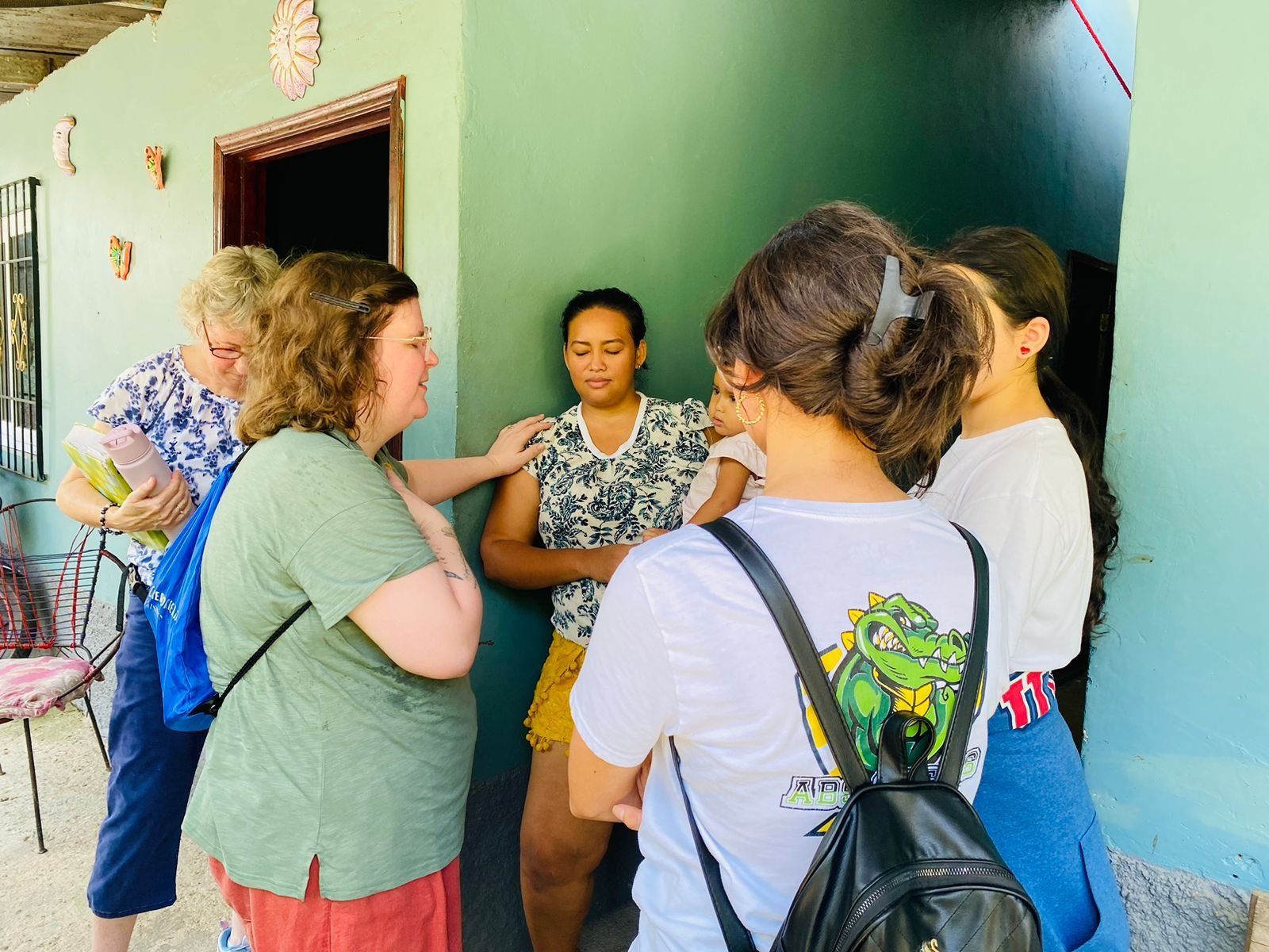 A group of women are standing outside of a building talking to each other.